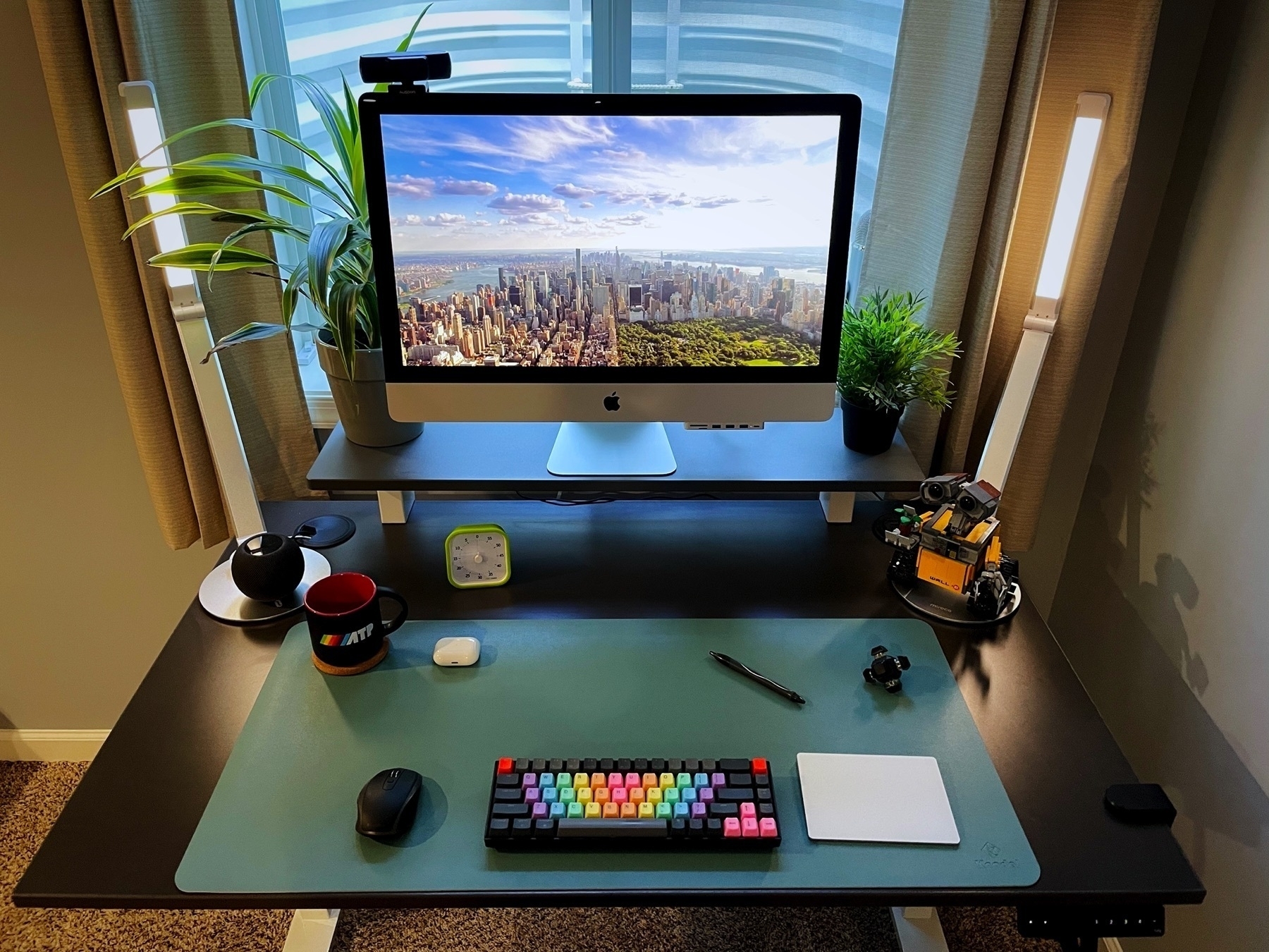 desk with computer in front of a window