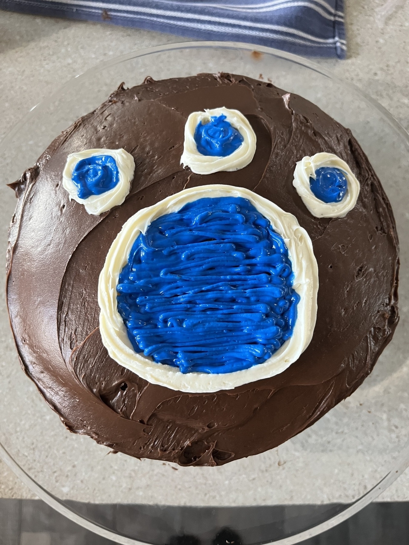 Chocolate cake with blue icing in the shape of a paw print