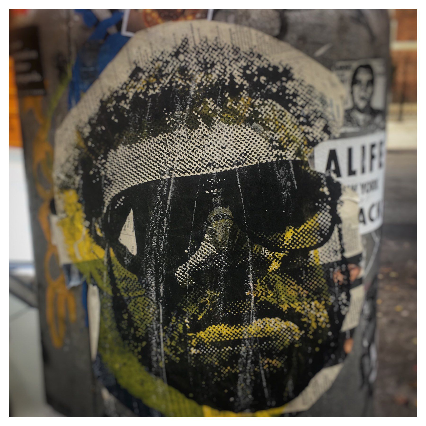 Sticker on a street pole of a tough guy wearing dark sunglasses
