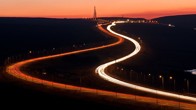 to forking roads at night, one lit and one dark