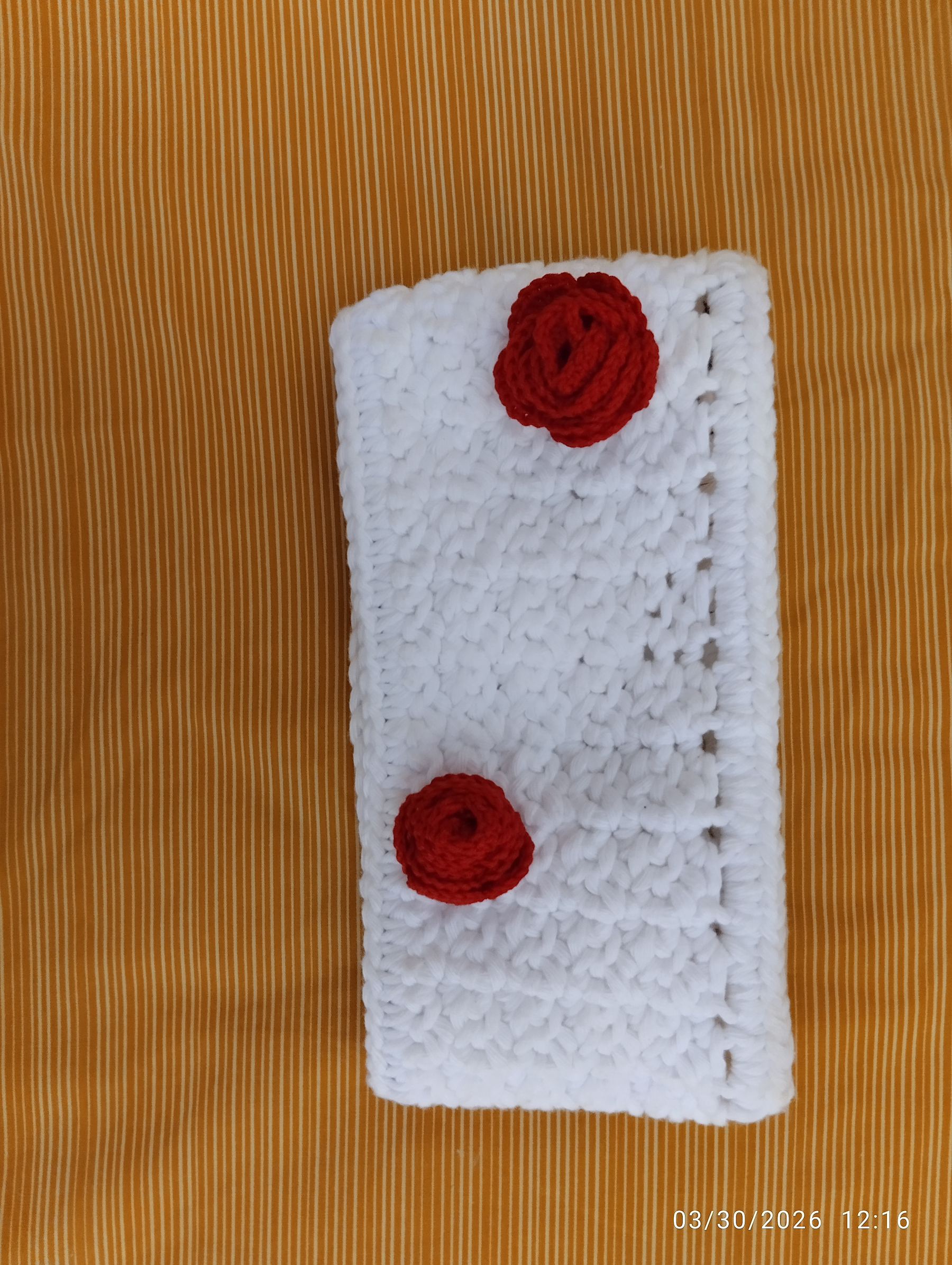 a white headband with red roses made with thread