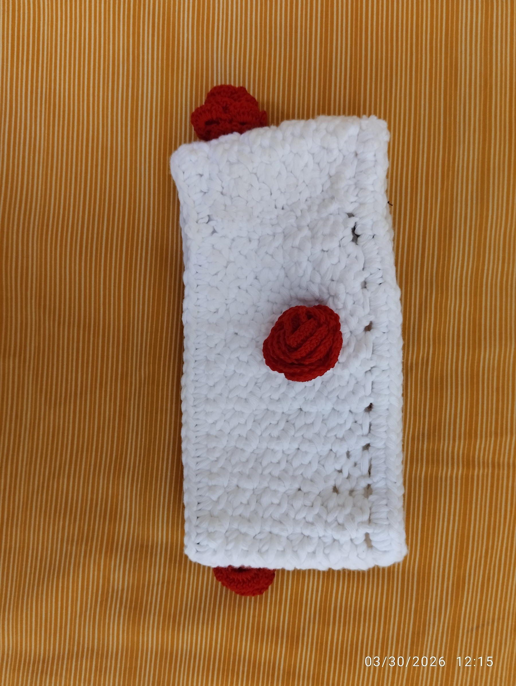 a white headband with red roses made with thread
