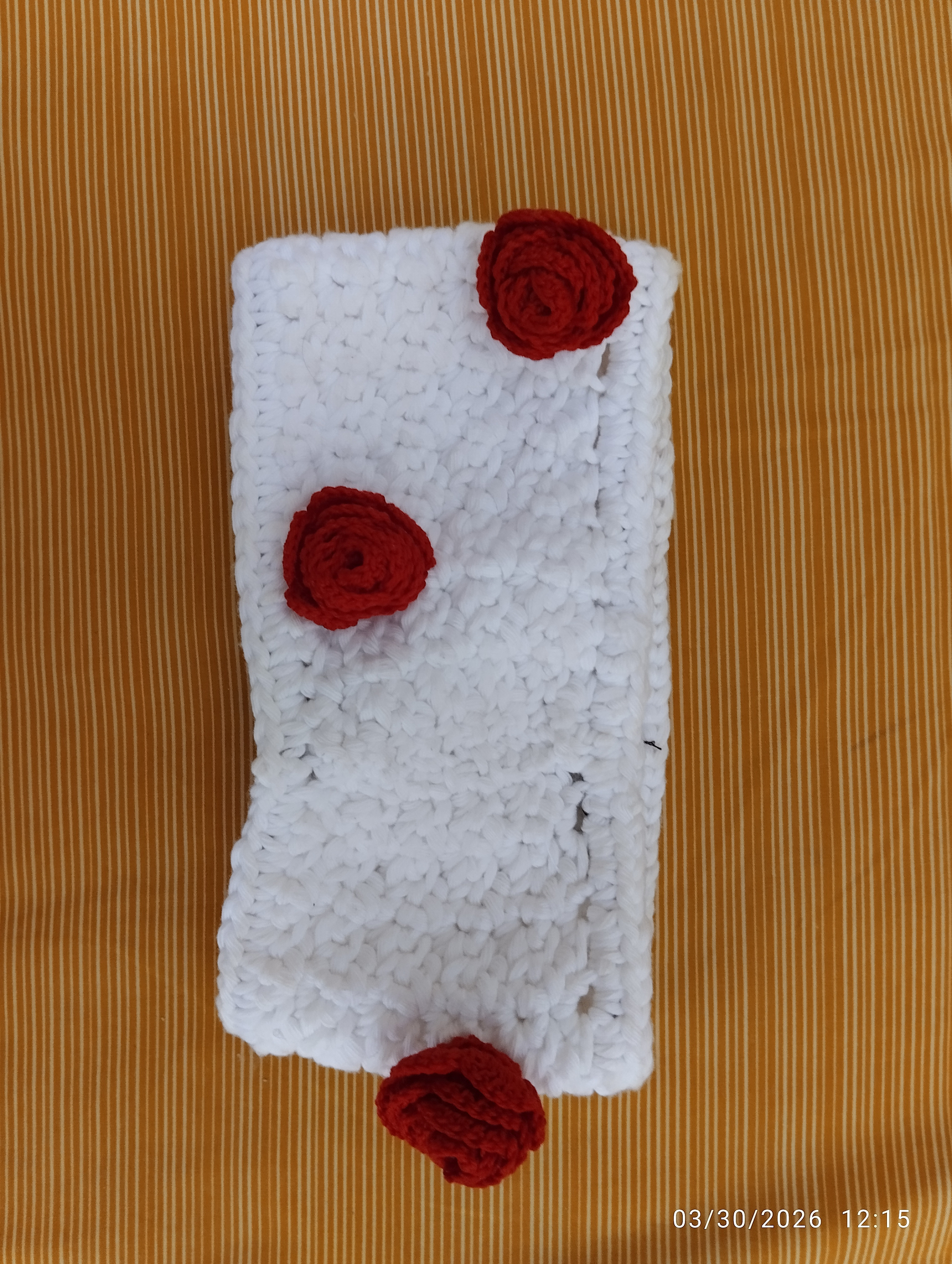 a white headband with red roses made with thread