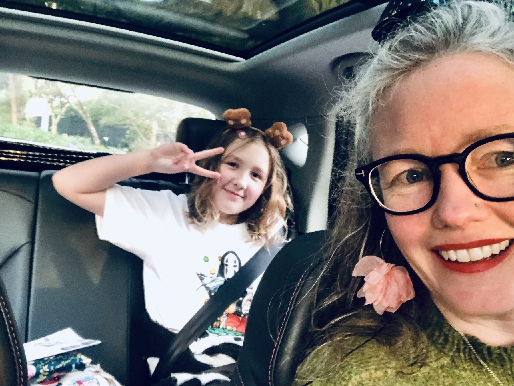 Young girl and mum dressed up and taking a selfie in the car before going to a party 