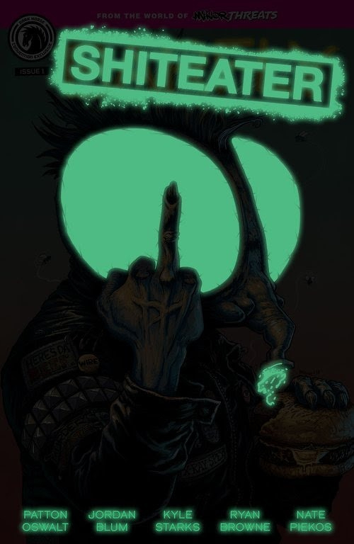 Auto-generated description: A dark, edgy comic book cover features a character with large glowing green eyes giving the middle finger while holding a sandwich, with the title SHITEATER prominently displayed.