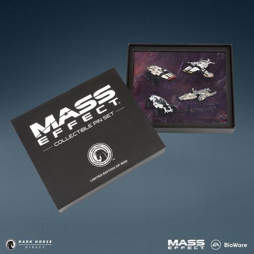 Auto-generated description: A limited edition Mass Effect collectible pin set featuring four spaceship-shaped pins is displayed alongside its black box packaging.