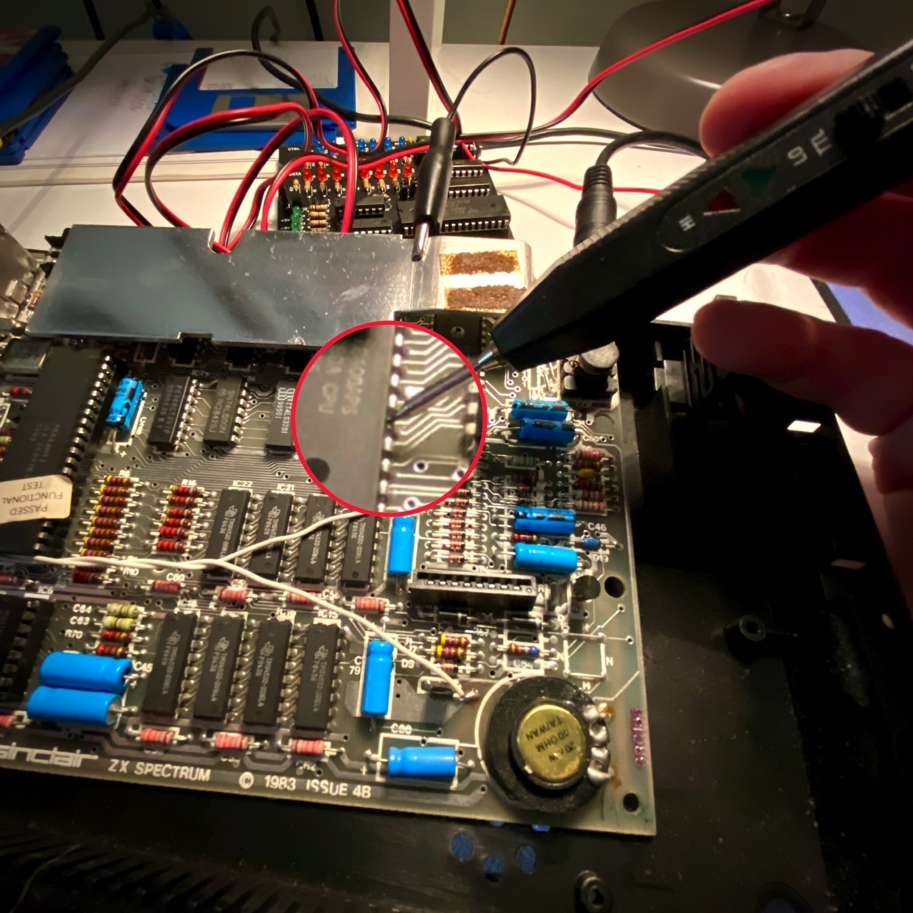 ZX Spectrum motherboard. The Z80 processor is being examined with a logic probe, but the probe is showing no activity.