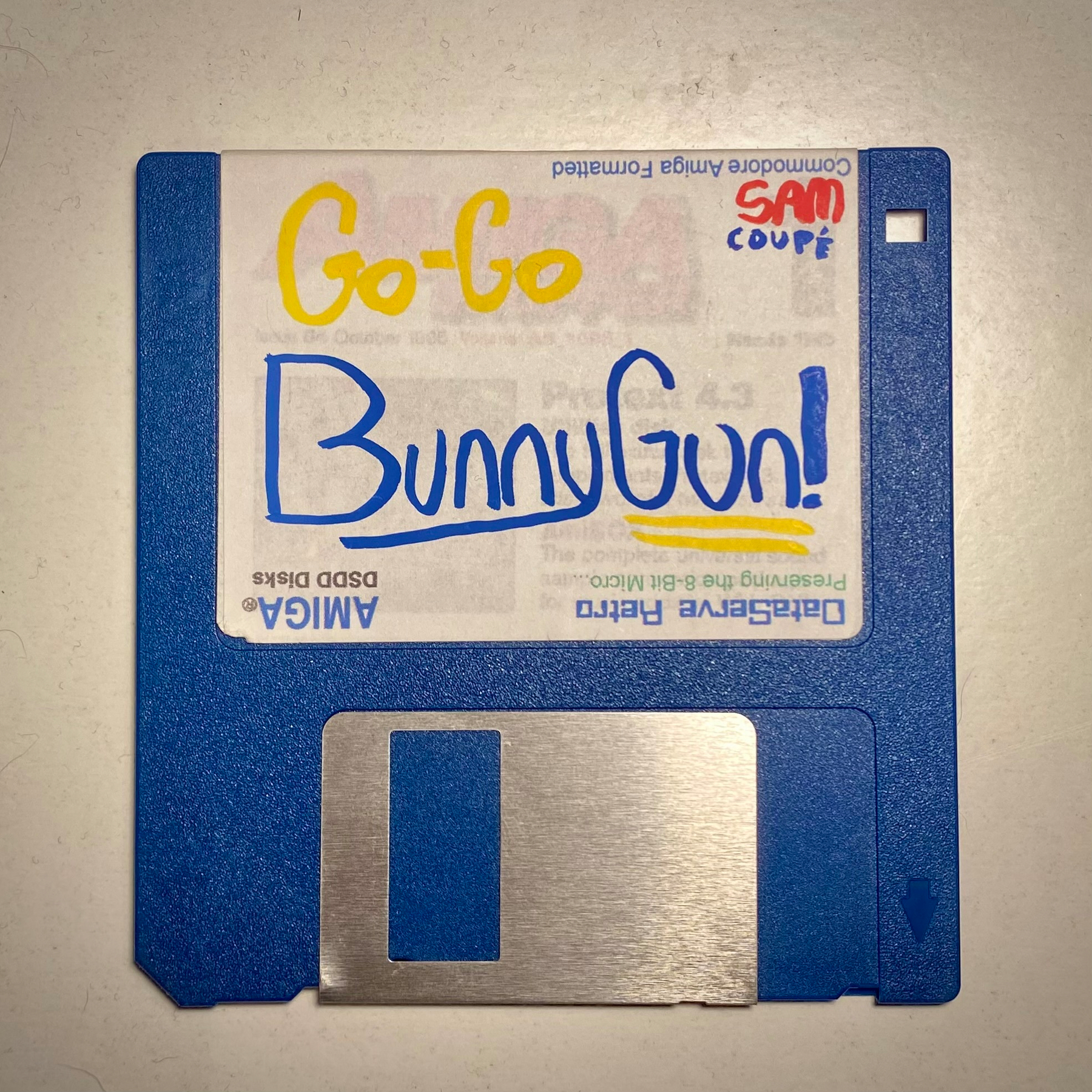 Photograph of a blue 3.5" floppy diskette, the label is hand written and reads “Go-Go BunnyGun!”