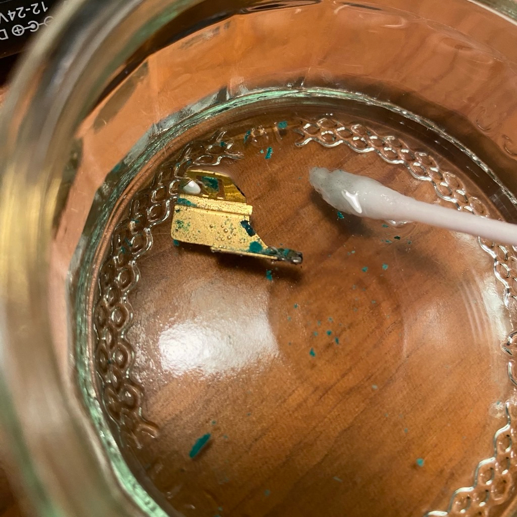 Battery terminal gently fizzing away in some vinegar.&10;Delicious-looking forbidden green crusty flakes float alluringly.