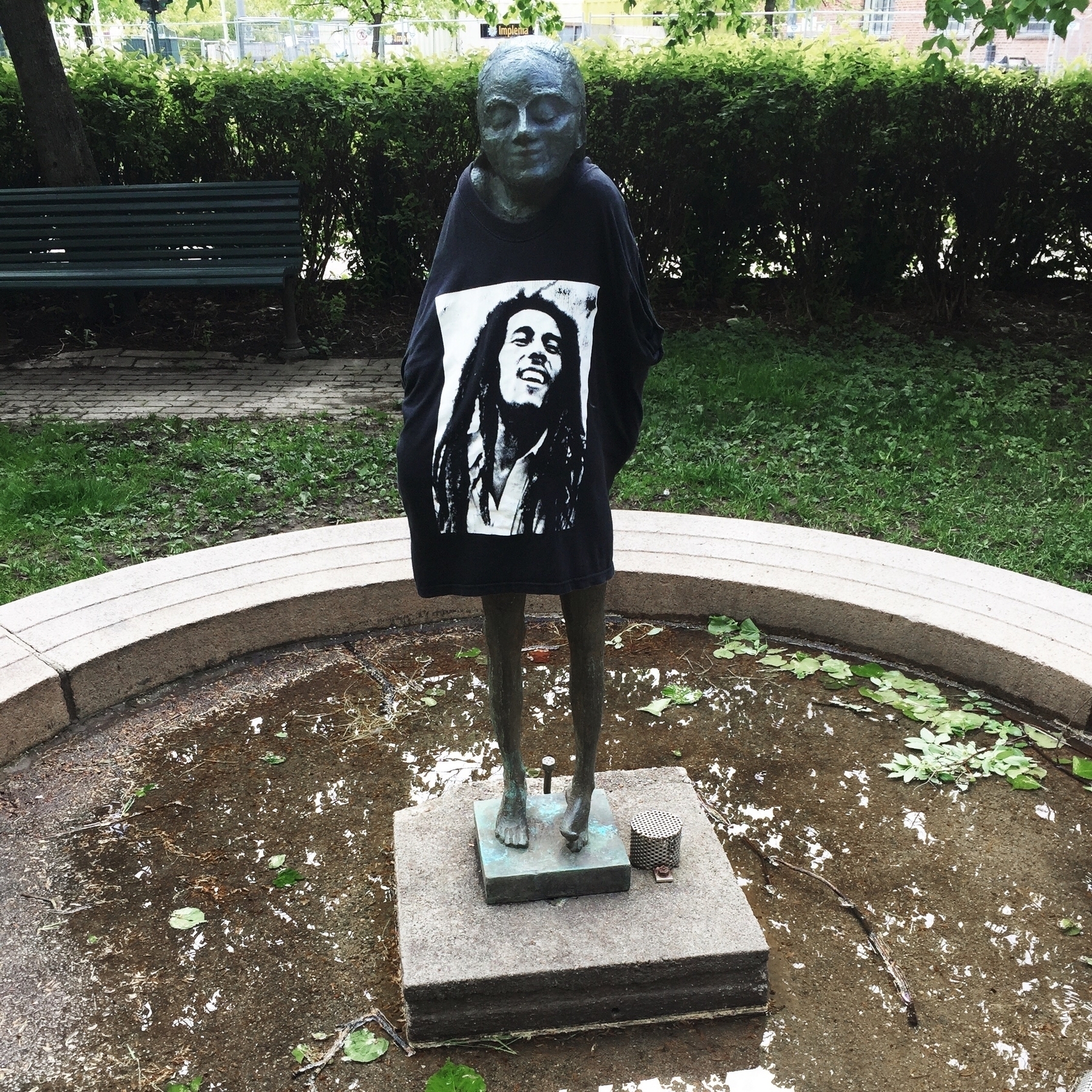 Statue in a fountain with a Bob Marley tee