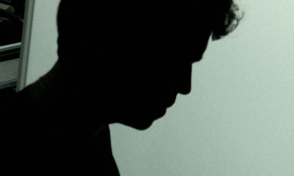a still from kalil haddad’s HIS SMELL, of the protagonist’s silhouette against a neutral background of an apartment’s interior