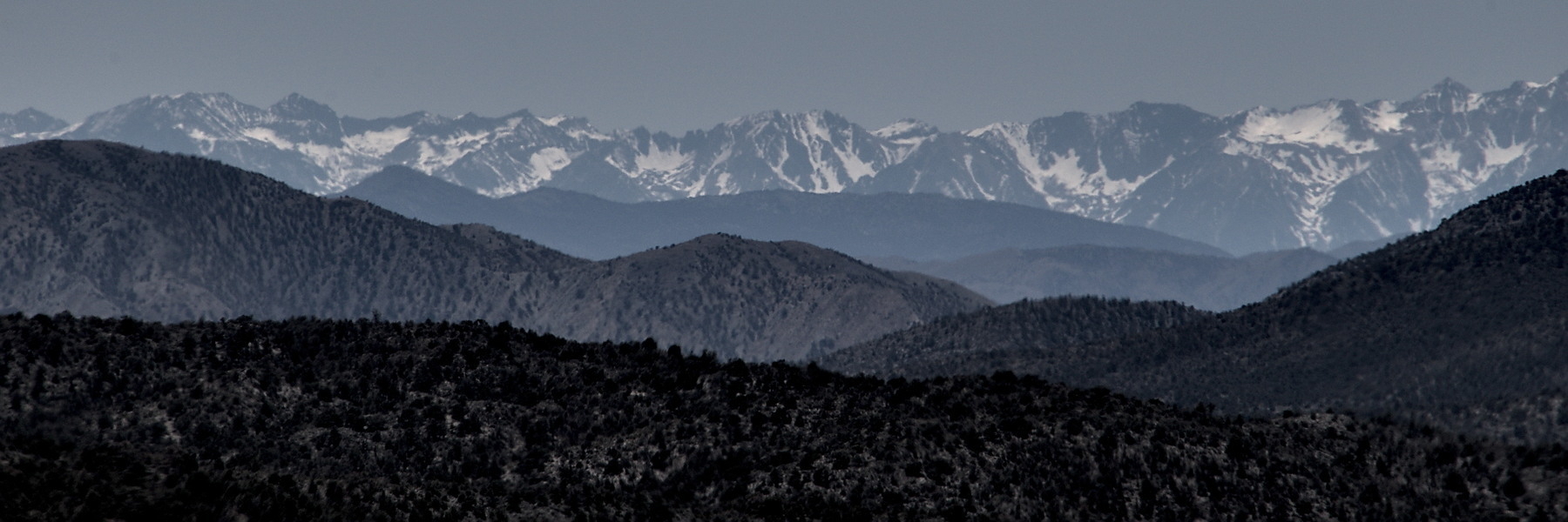 Layers of mountains receding into the distance. The last range is snow-capped.