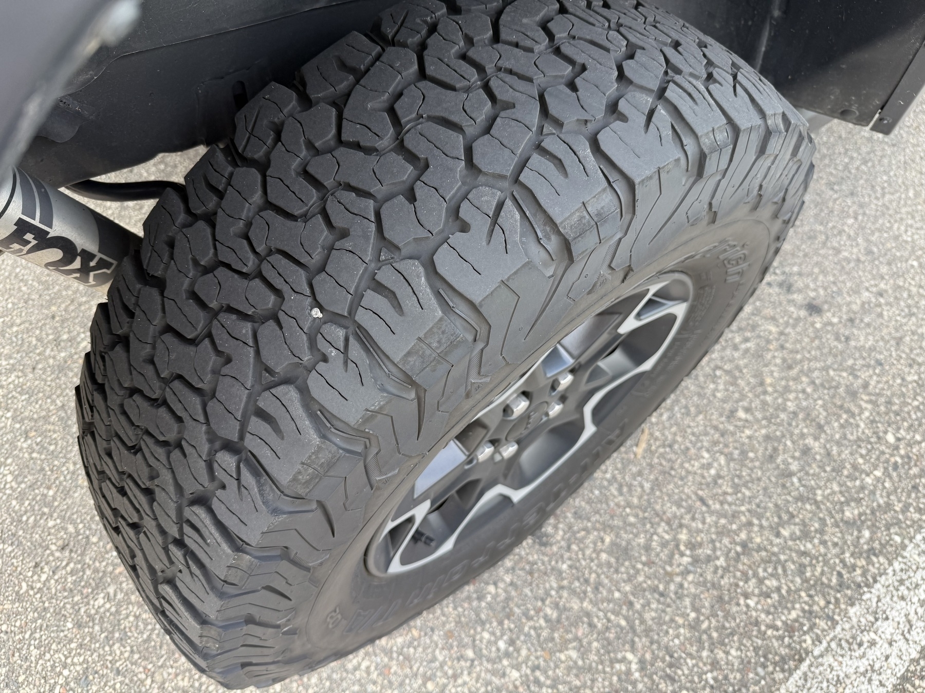Close-up view of a rugged, all-terrain vehicle tire with a distinctive tread pattern, suitable for off-road driving.