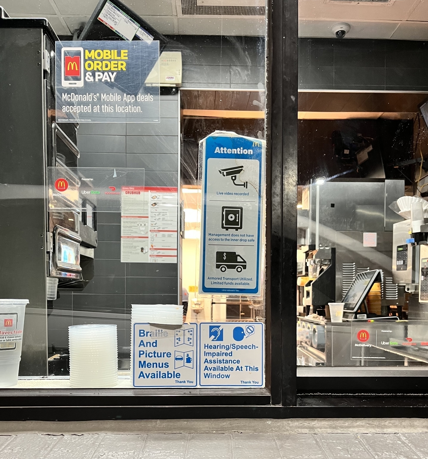 McDonald’s drive through window with signs and warnings. 
