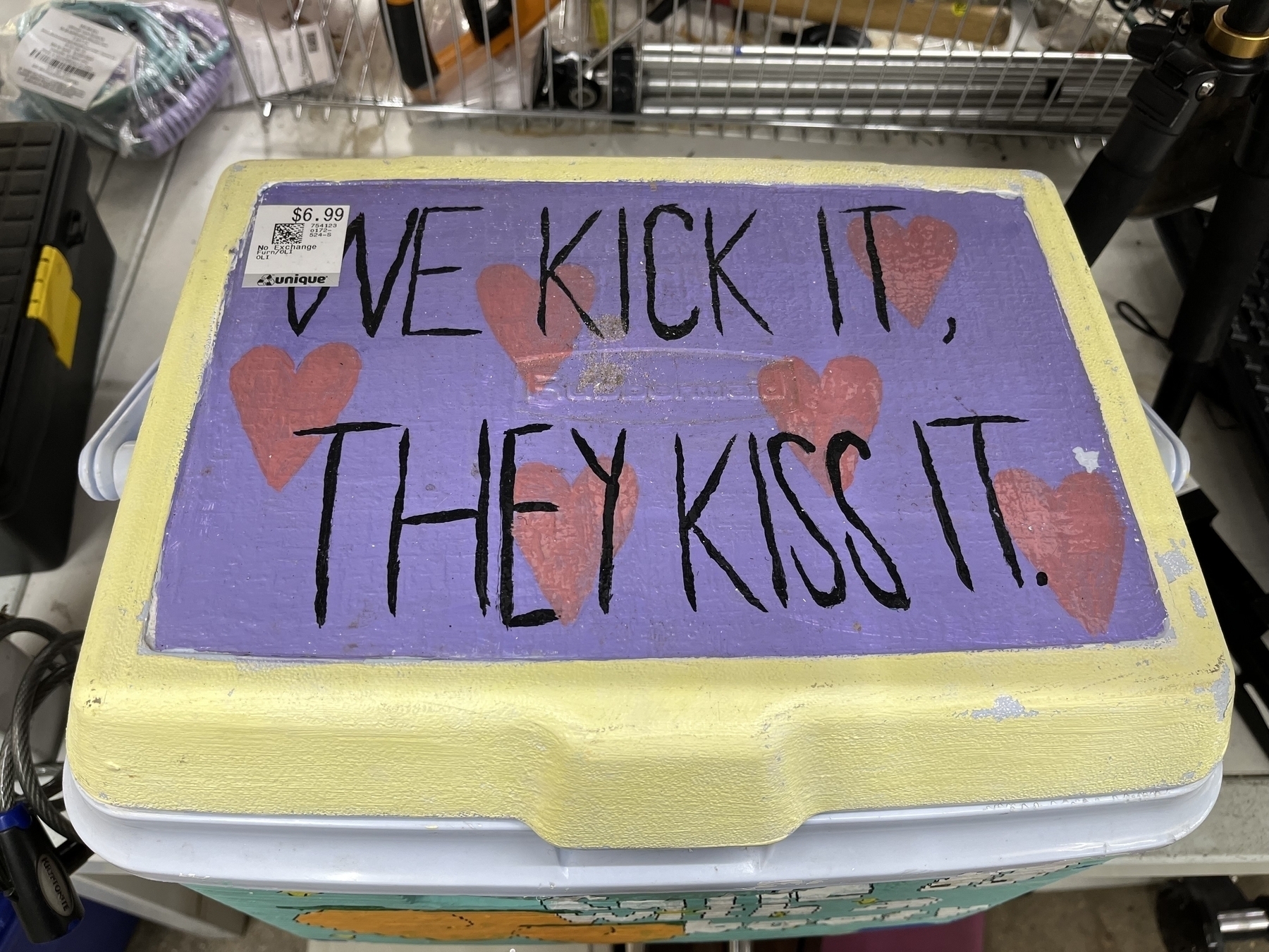 Cooler lid with hand painted hearts that says We kick it, they kiss it. 