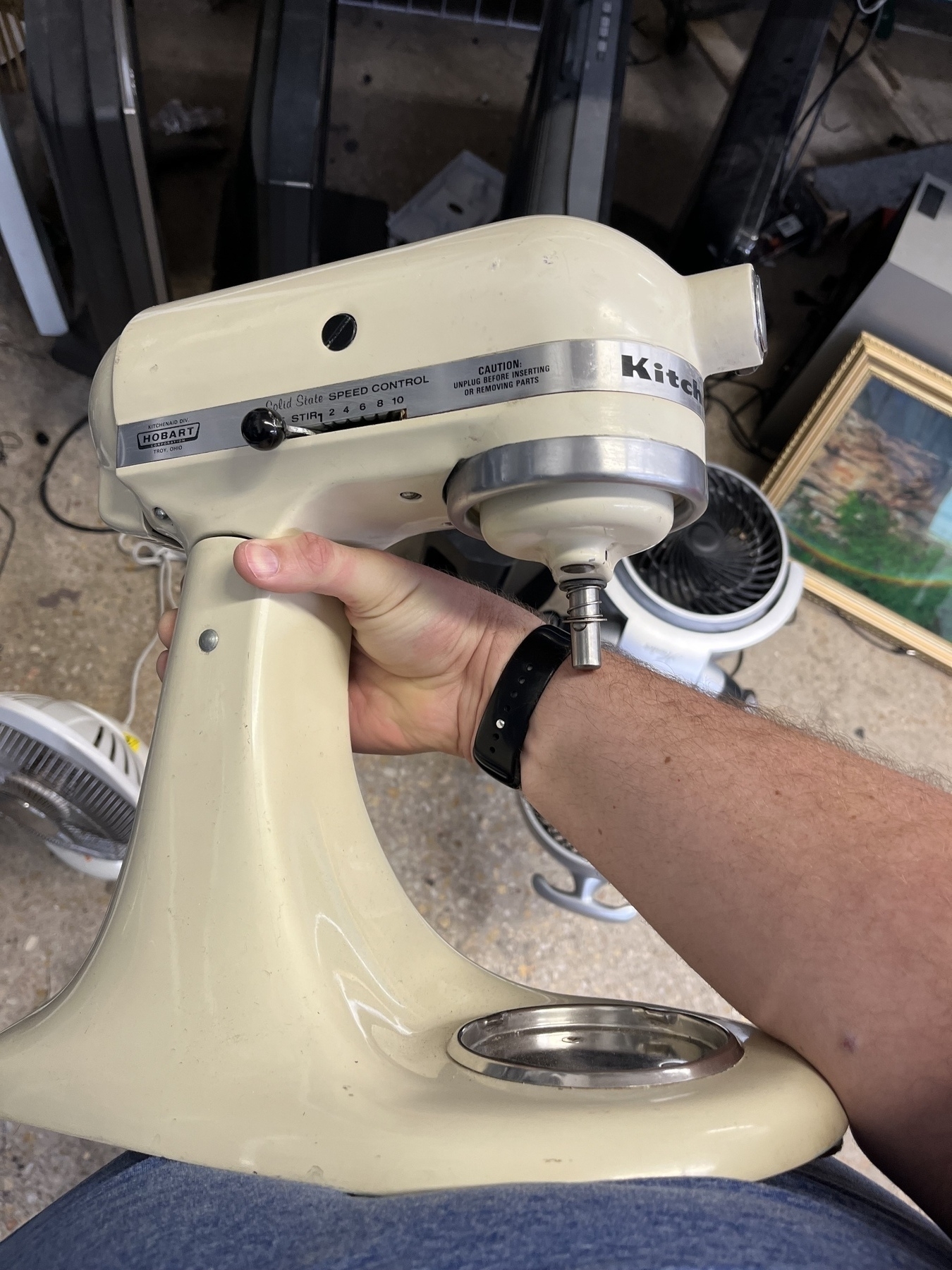 KitchenAid mixer being held up in a thrift store. 