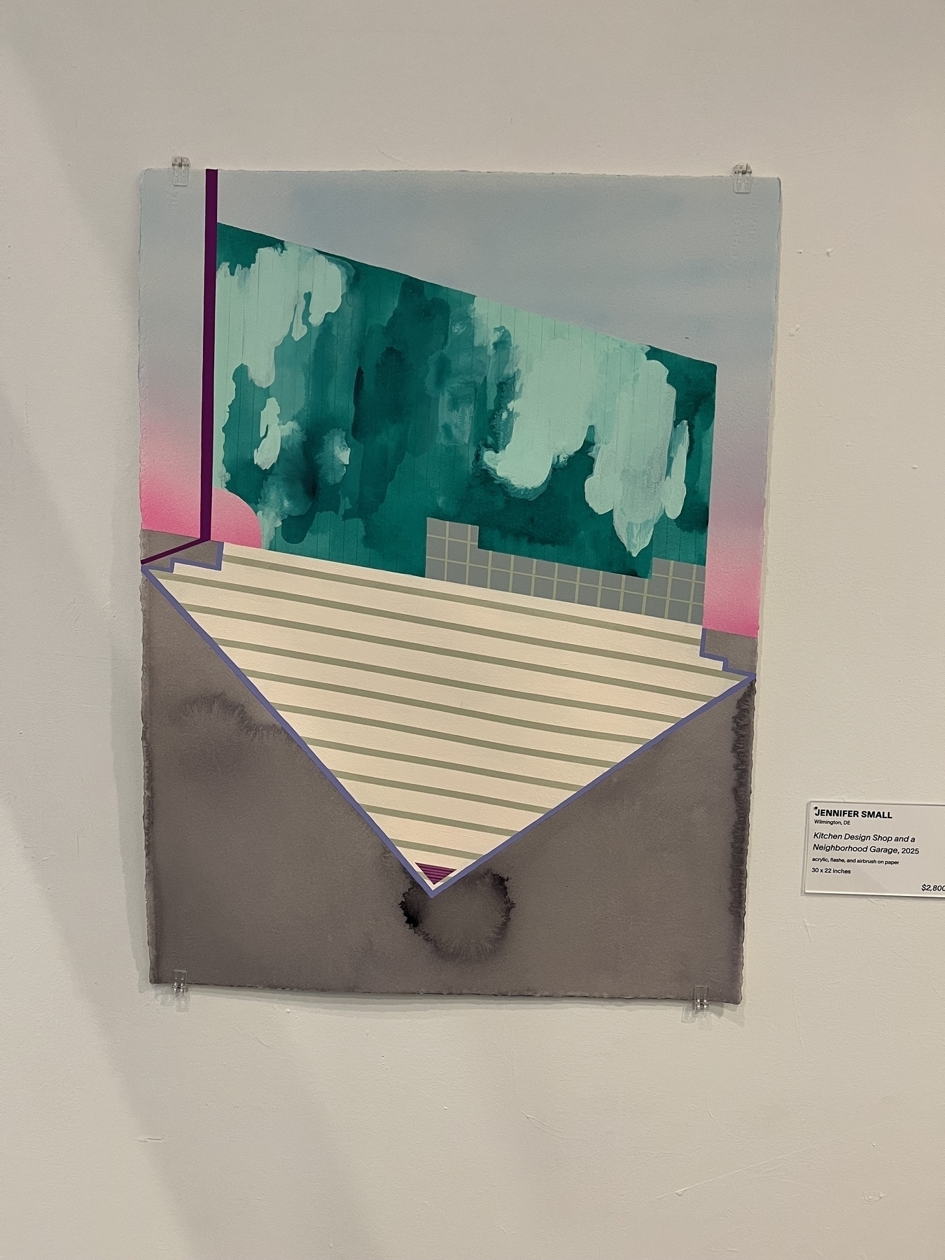 Abstract artwork features geometric shapes with green and pink hues intersecting over a striped, triangular form, set against a gray backdrop. A label reads: “Jennifer Small, Kitchen Design Shop and a Neighborhood Garage, 2025, $2,800”.