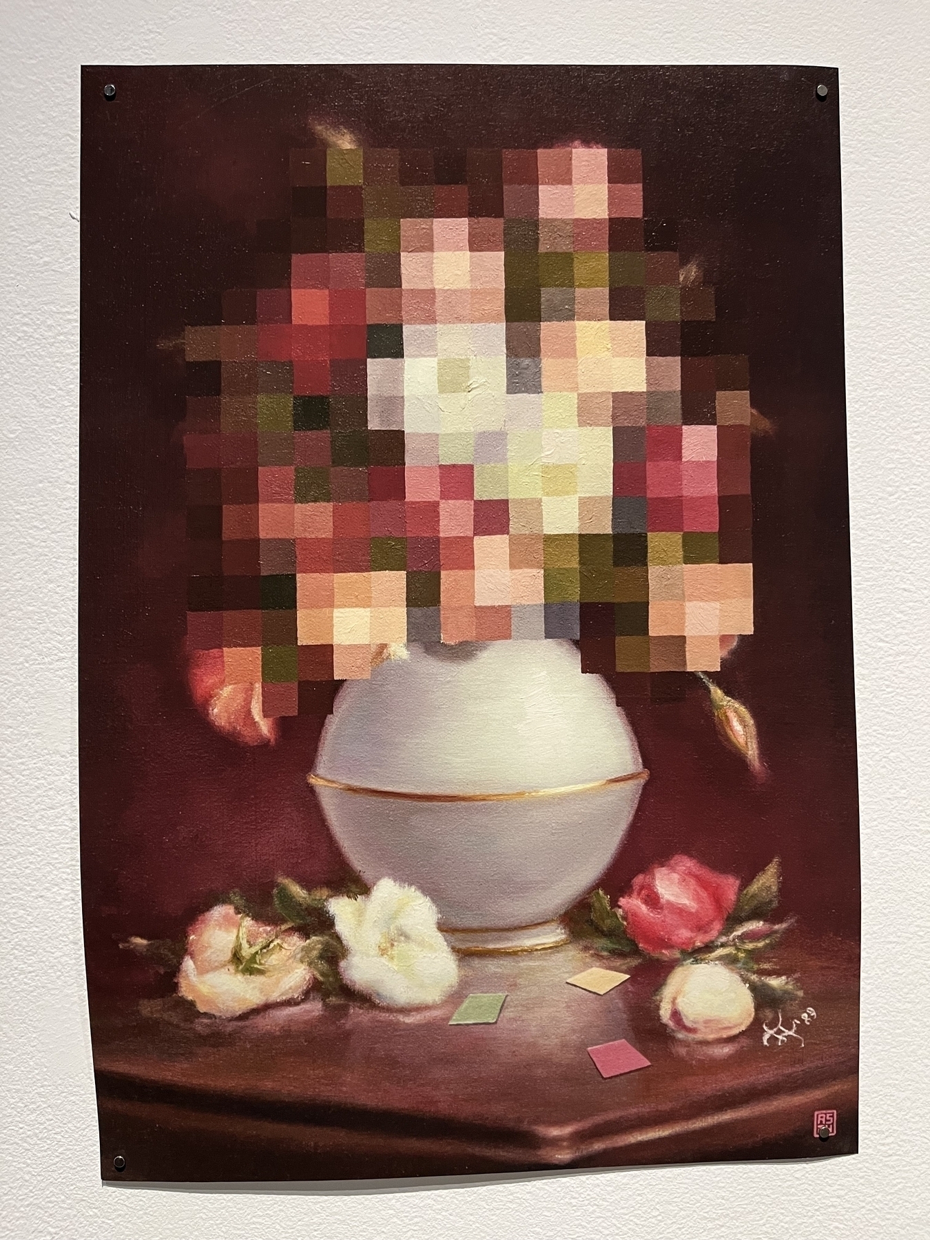 A pixelated bouquet of flowers is arranged in a white vase, sitting on a wooden table with scattered pastel color swatches around it, against a dark background.