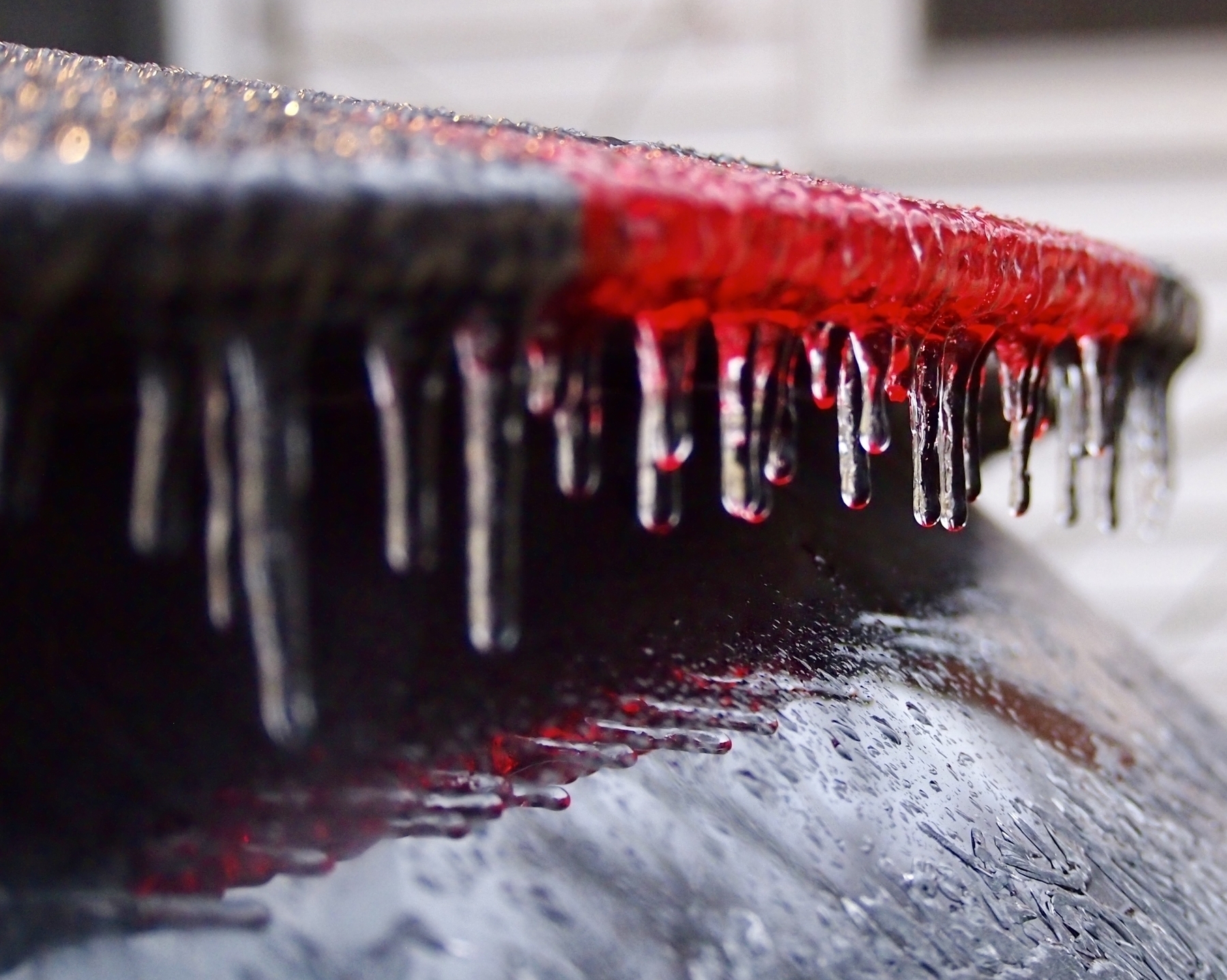 Icicles hang from the edge a car’s roof, sparkling as they form a line after a freezing rain. 