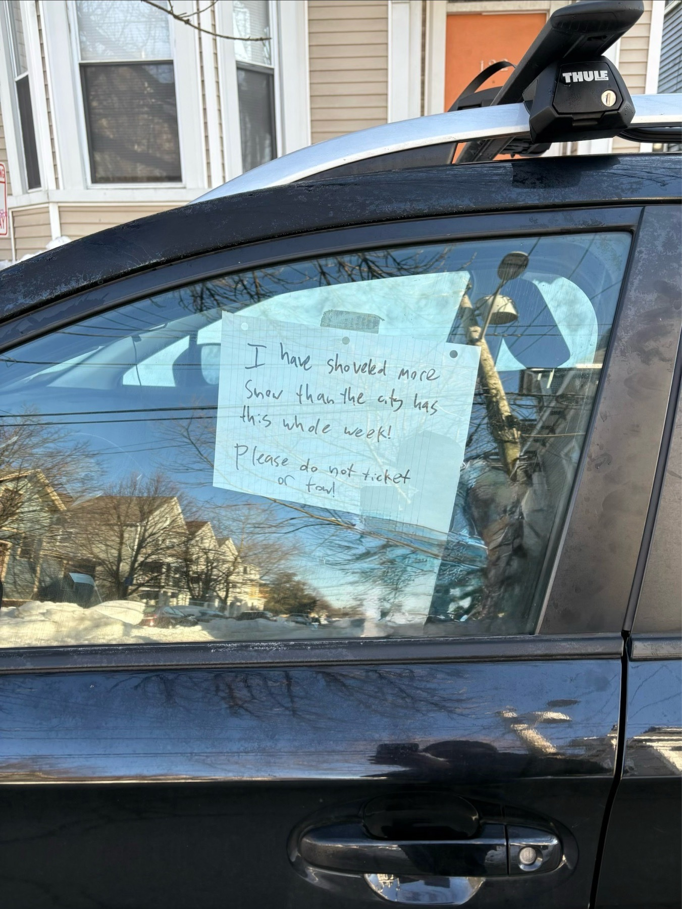 A piece of paper is taped to the inside of a drivers side car window. It reads, โI have shoveled more snow than the city has this whole week! Please do not ticket or tow!โ
