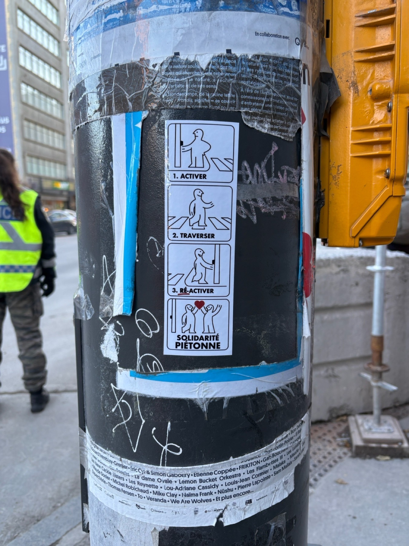 A vertical sticker with four panels drawn in the style of IKEA manuals is on a lampost on a city corner, with torn remains of prior postings all around it. The four panels are labeled “Activer”, “Traverser”, “Ré-Activer”, and “Solidarité Pietonne”, illustrating how to use the crosswalk sensors for pedestrian solidarity.