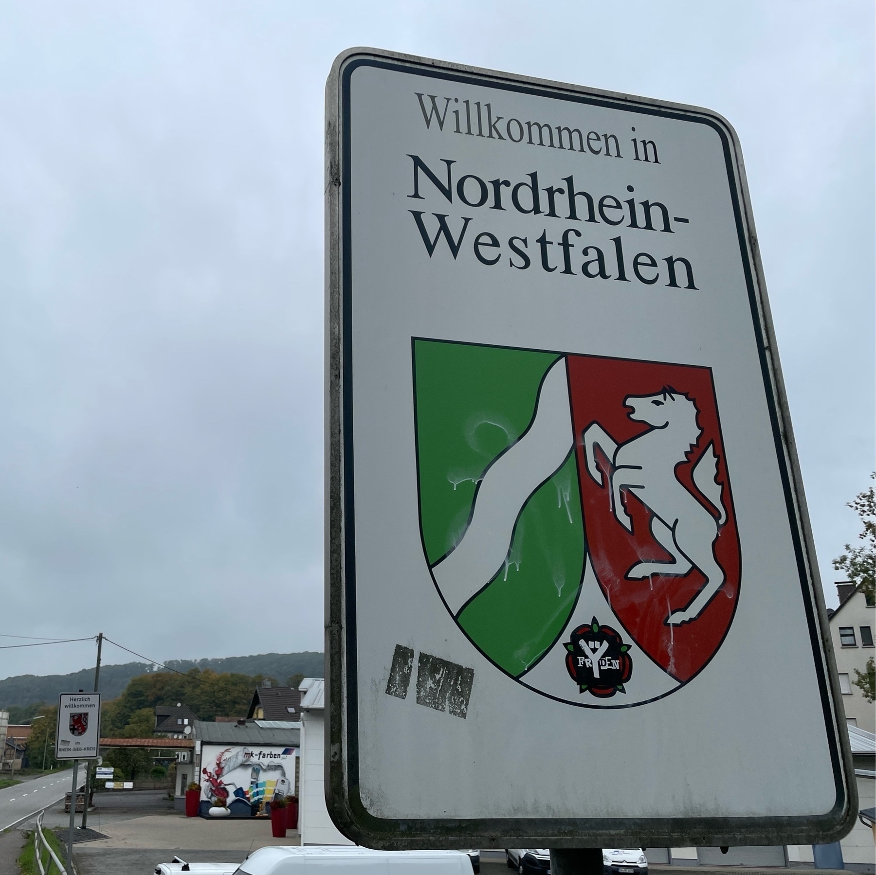 sign “Wilkommen in Nordrhein-Westfalen” – Welcome to Northrhine Westphalia. It includes the red and green coat of arms. 