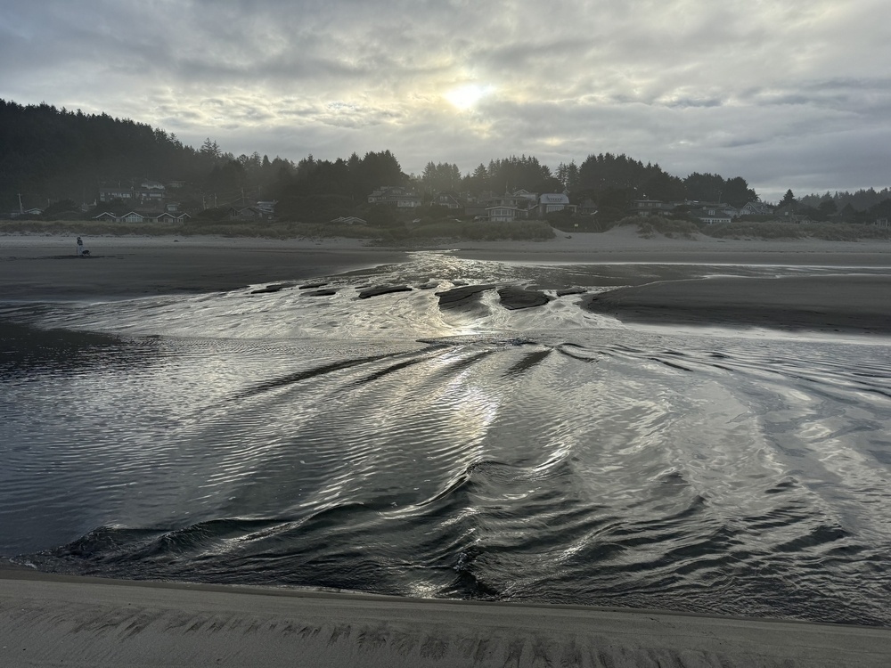 Ocean waves reflecting off the bank of a beach creek. 