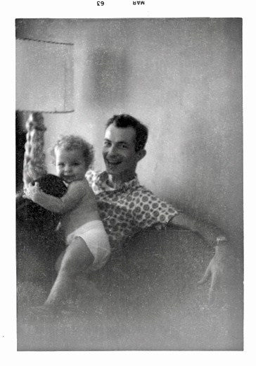 scan of an old black-and-white photo of a happy young man and his happy baby