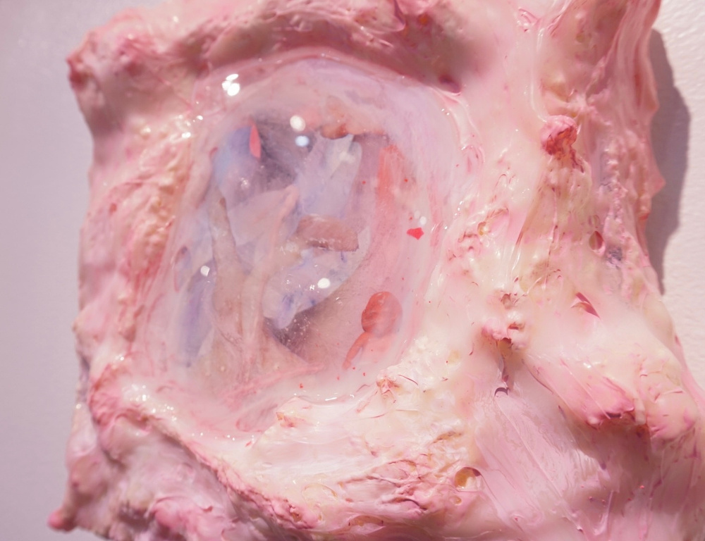 A textured, abstract sculpture featuring pink and white materials with a translucent center resembling an organic formation.