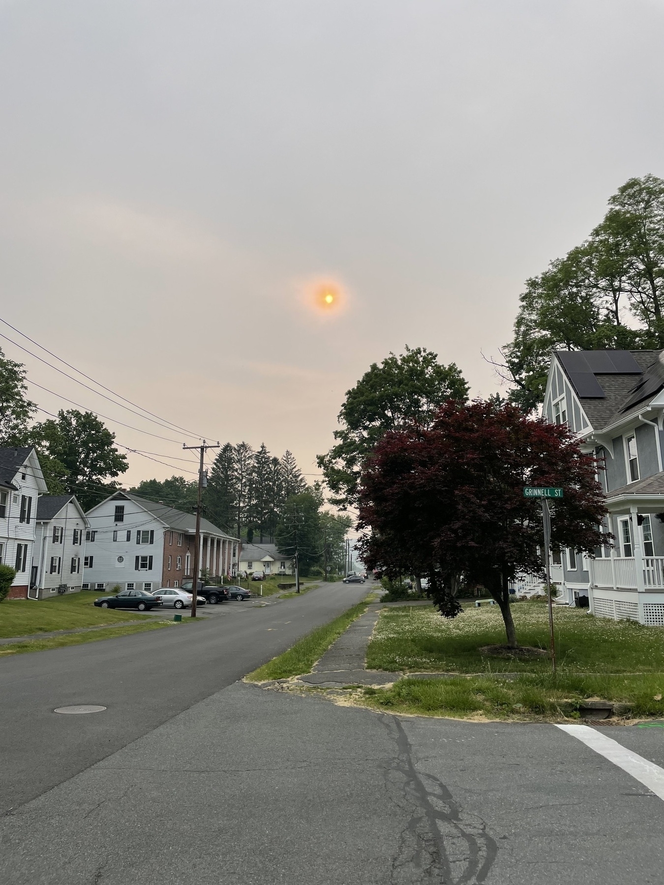 Weird orange sun over neighborhood street
