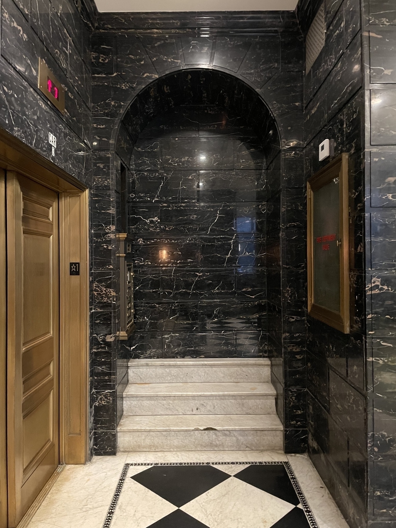 Several marble steps up to a bricked-up door 