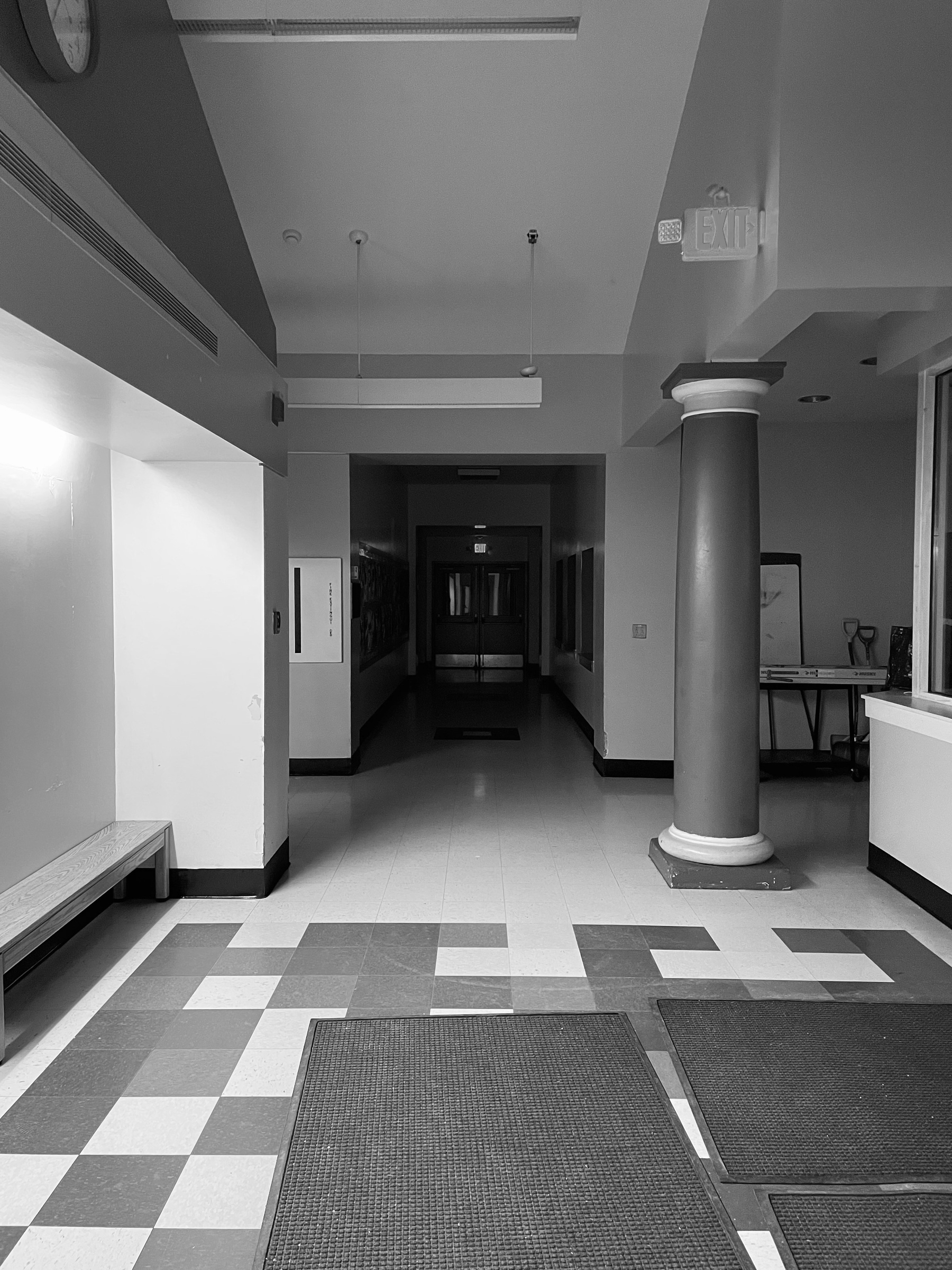 Black and white photo of a school hallway at night
