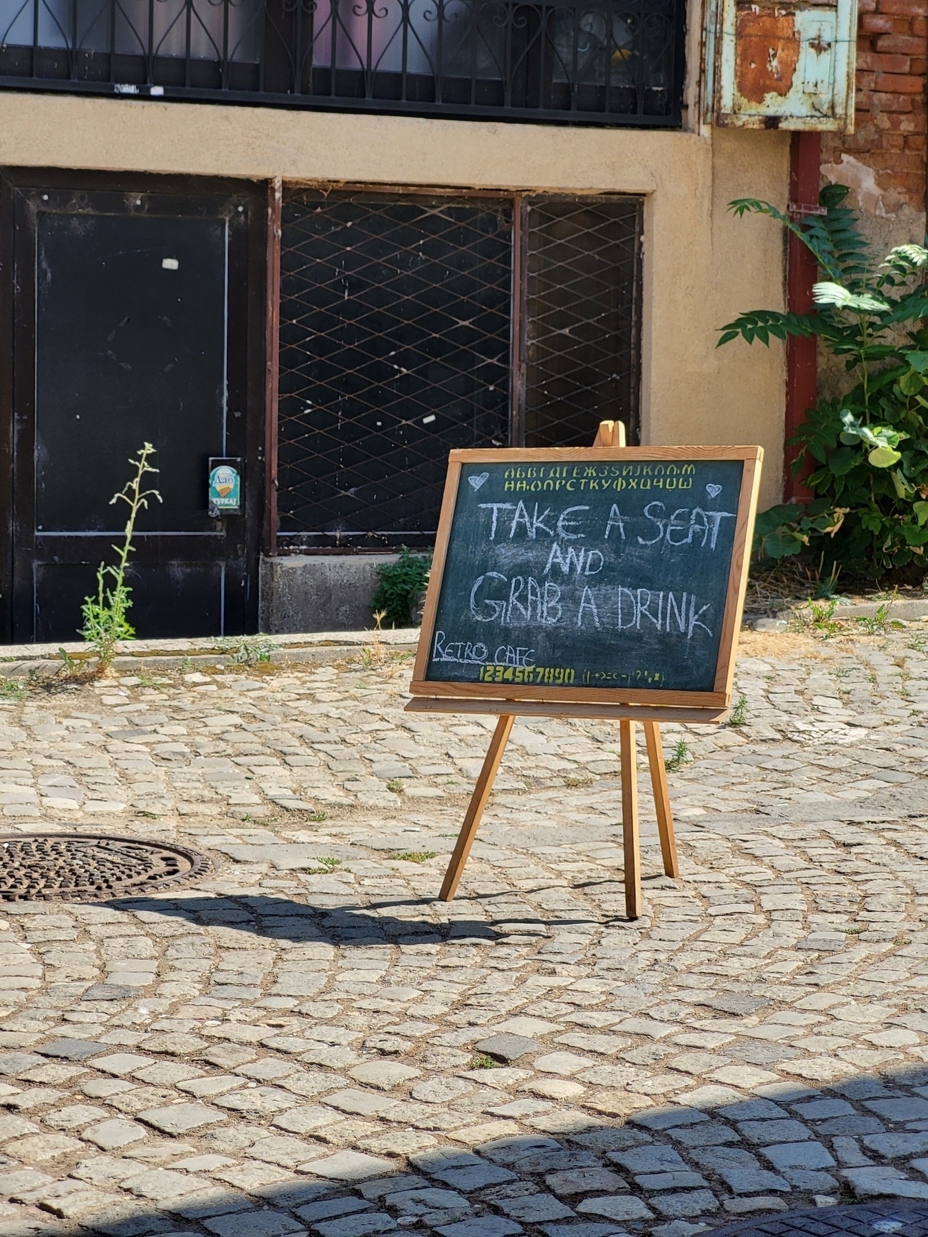 Sign with "take a seat and grab a drink" written 