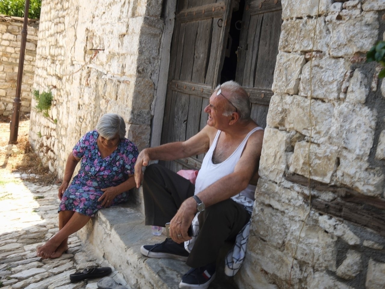 Elderly couple sitting down on a doorway 