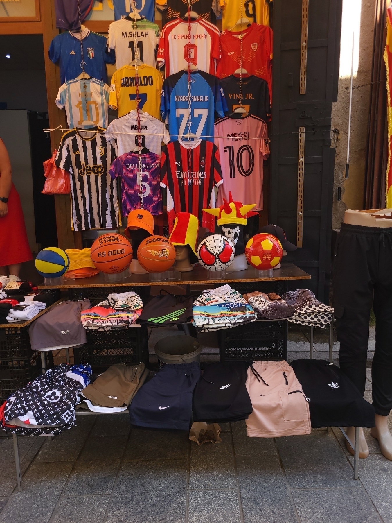 Football shirts on a stand in a street 