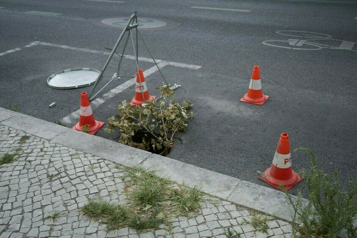 Orang pins around hole in the street