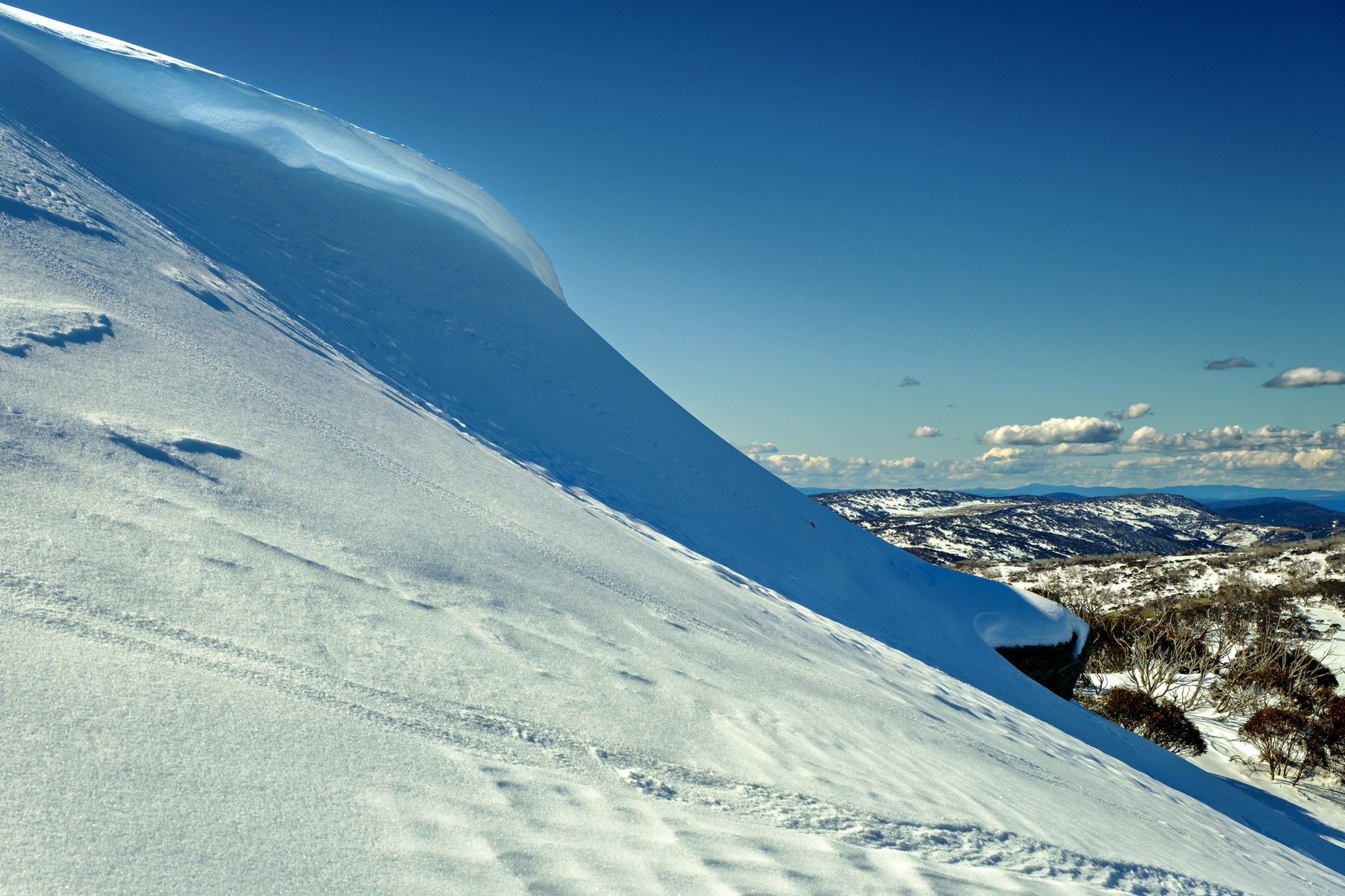 A snow cornice at Mt Wheatley in the NSW ski fields, with a blue sky behind.