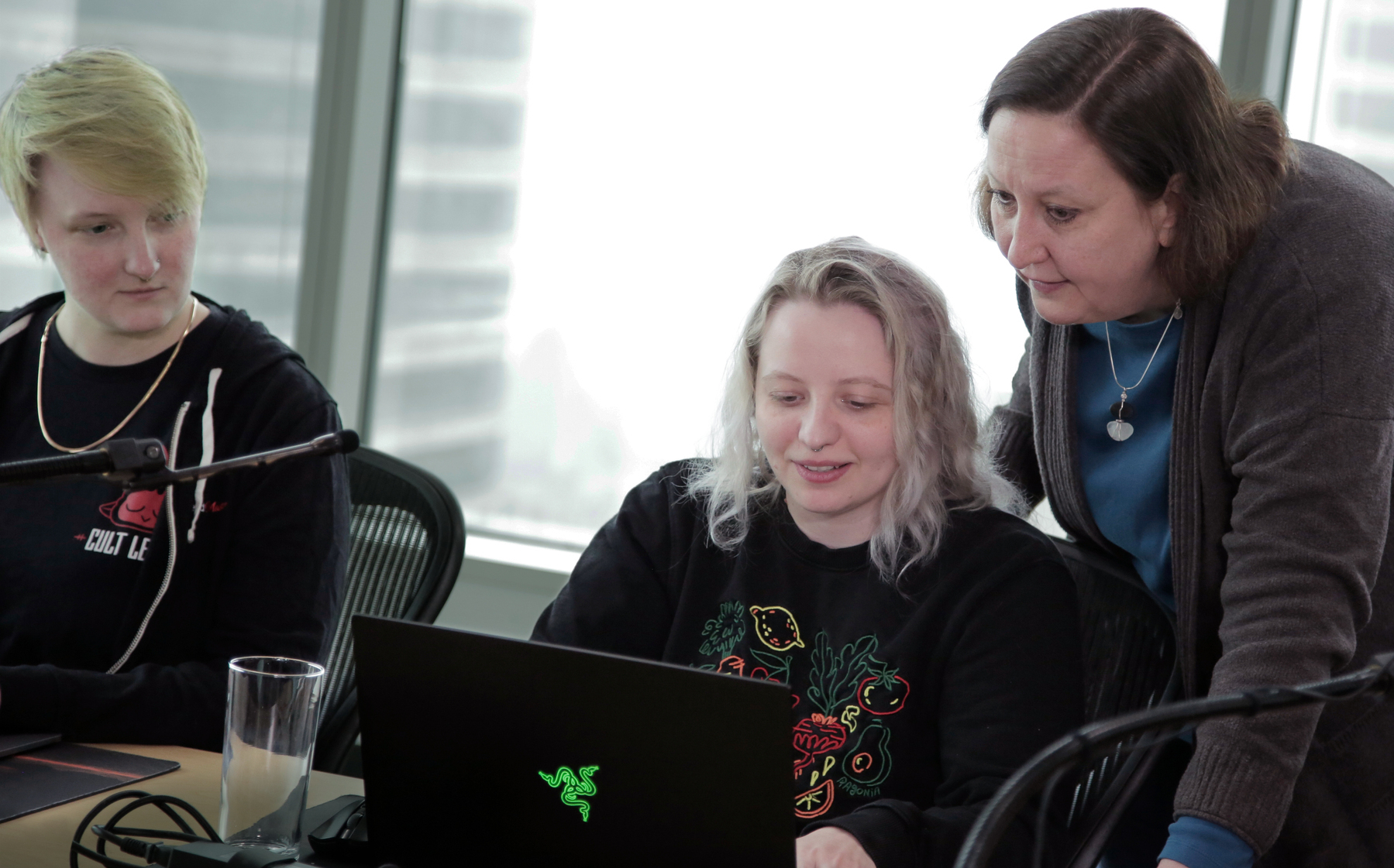 Jen at Frontend Masters, assisting two students with their code.