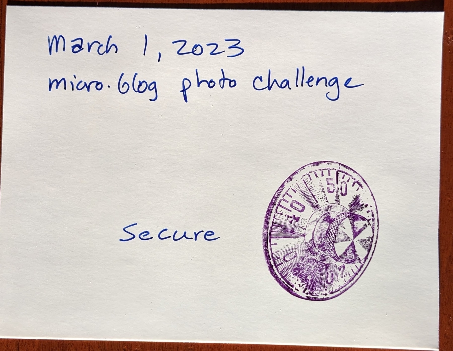 postcard rubber stamped with image of a combination lock