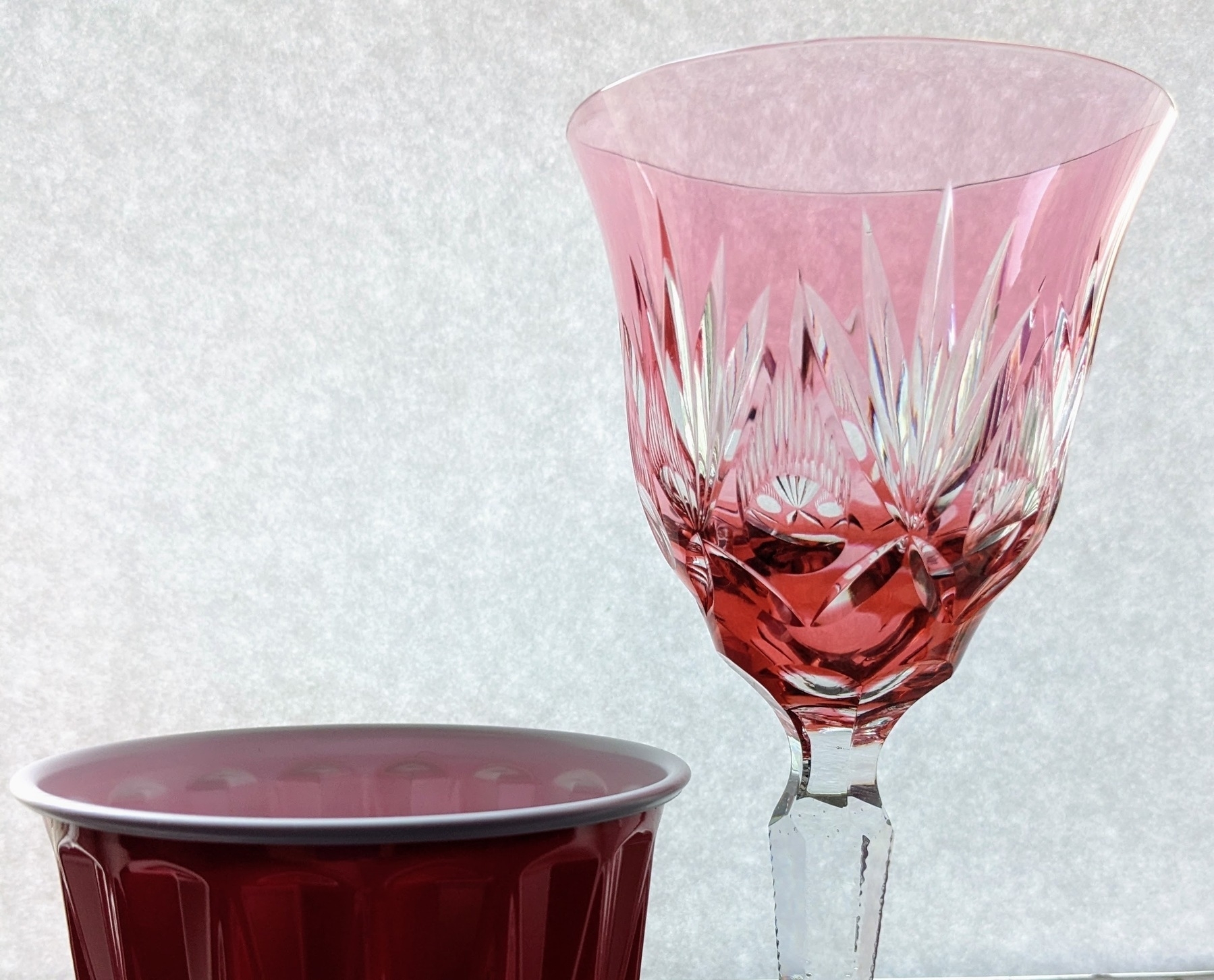 a plastic disposable cup is placed next to a crystal goblet