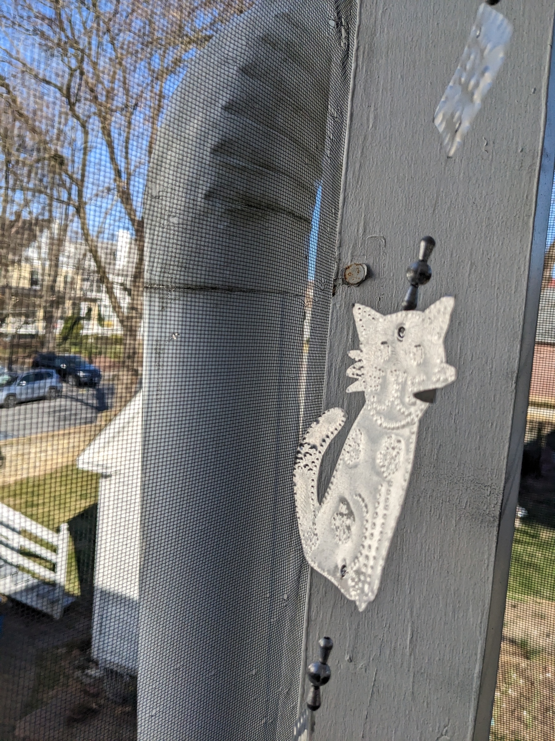 foil decorative cut-out of a cat on a screened porch