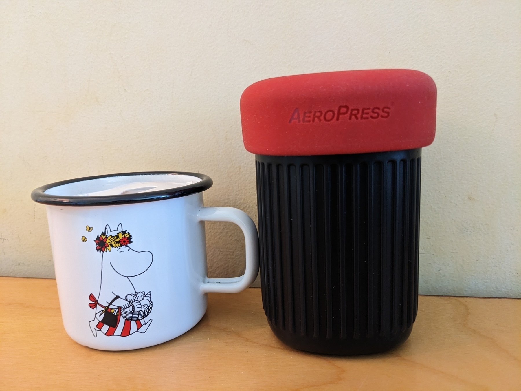 coffee mug next to Aeropress travel coffee maker