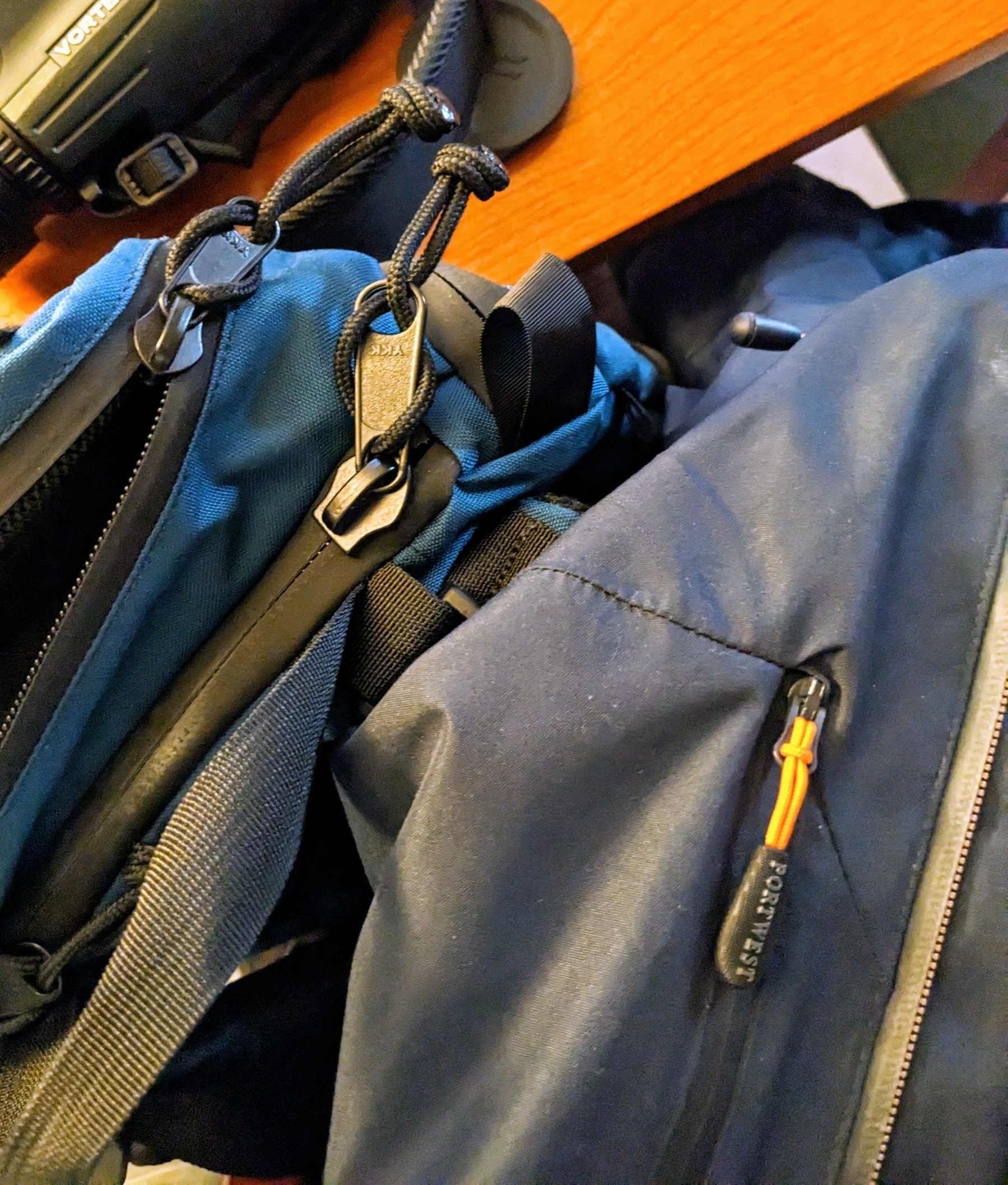 backpack next to a jacket, with zippers showing