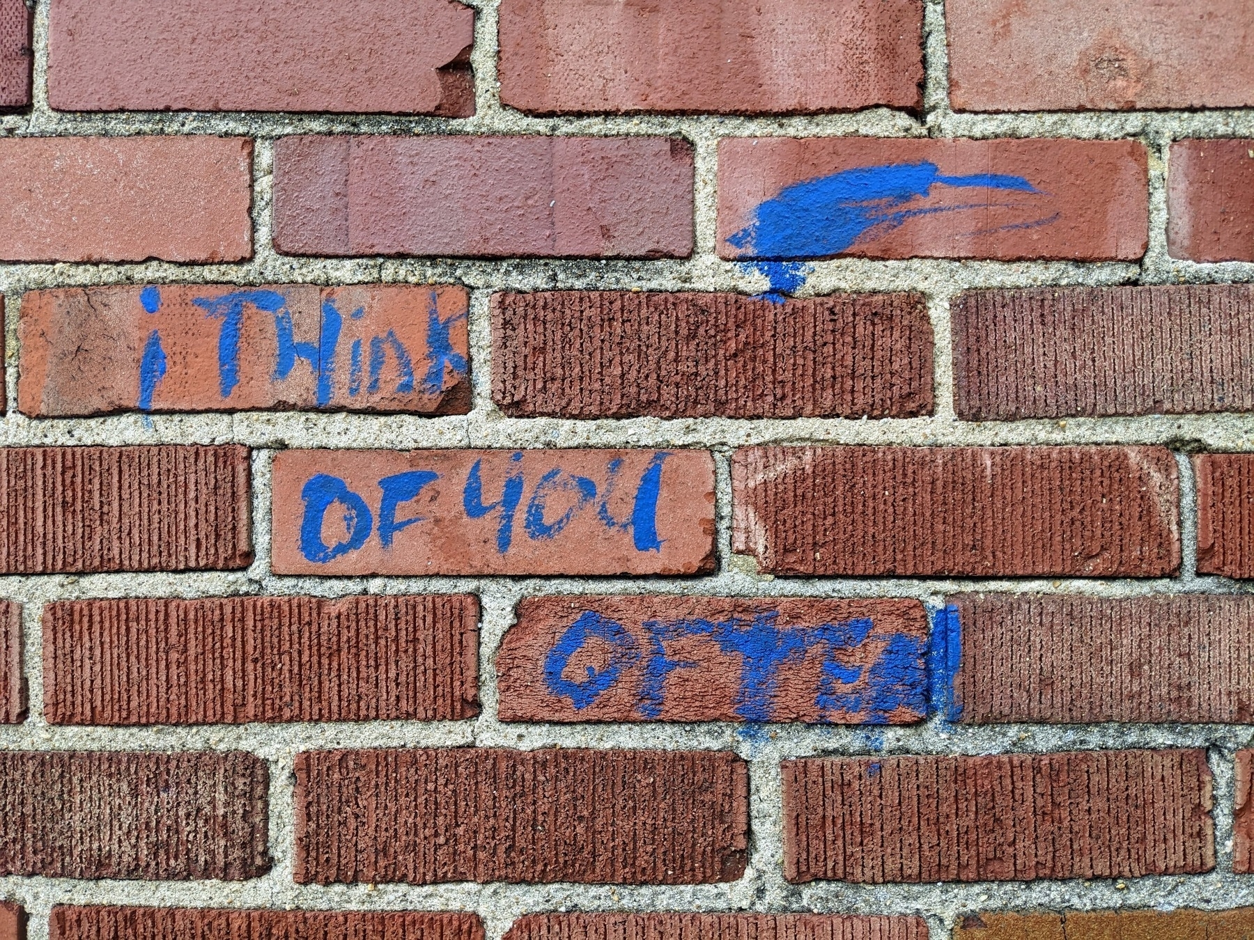 graffiti painted on old brick wall, quote, i think of you often, unquote