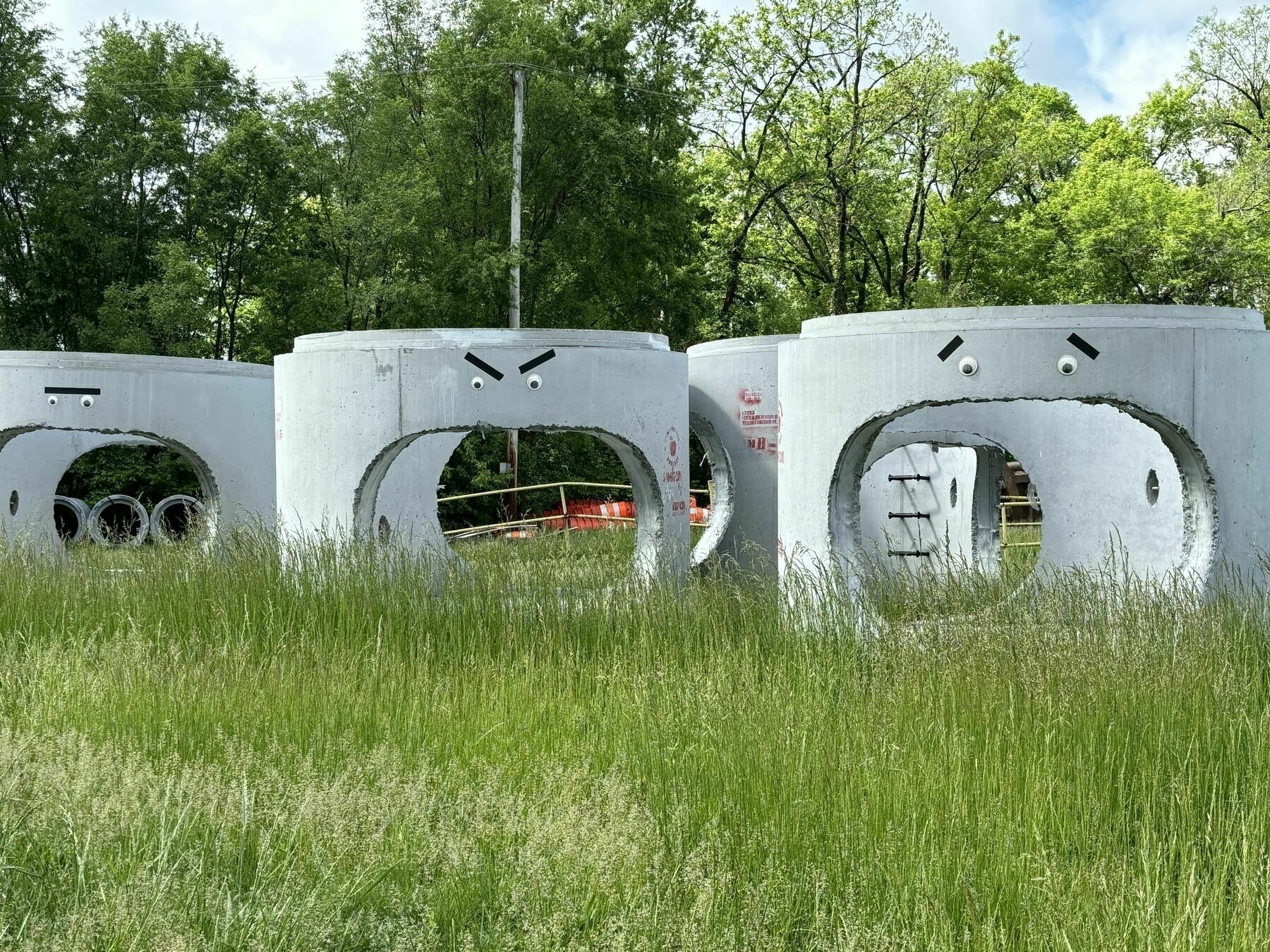 giant concrete pipes in construction lot with googly eyes on them