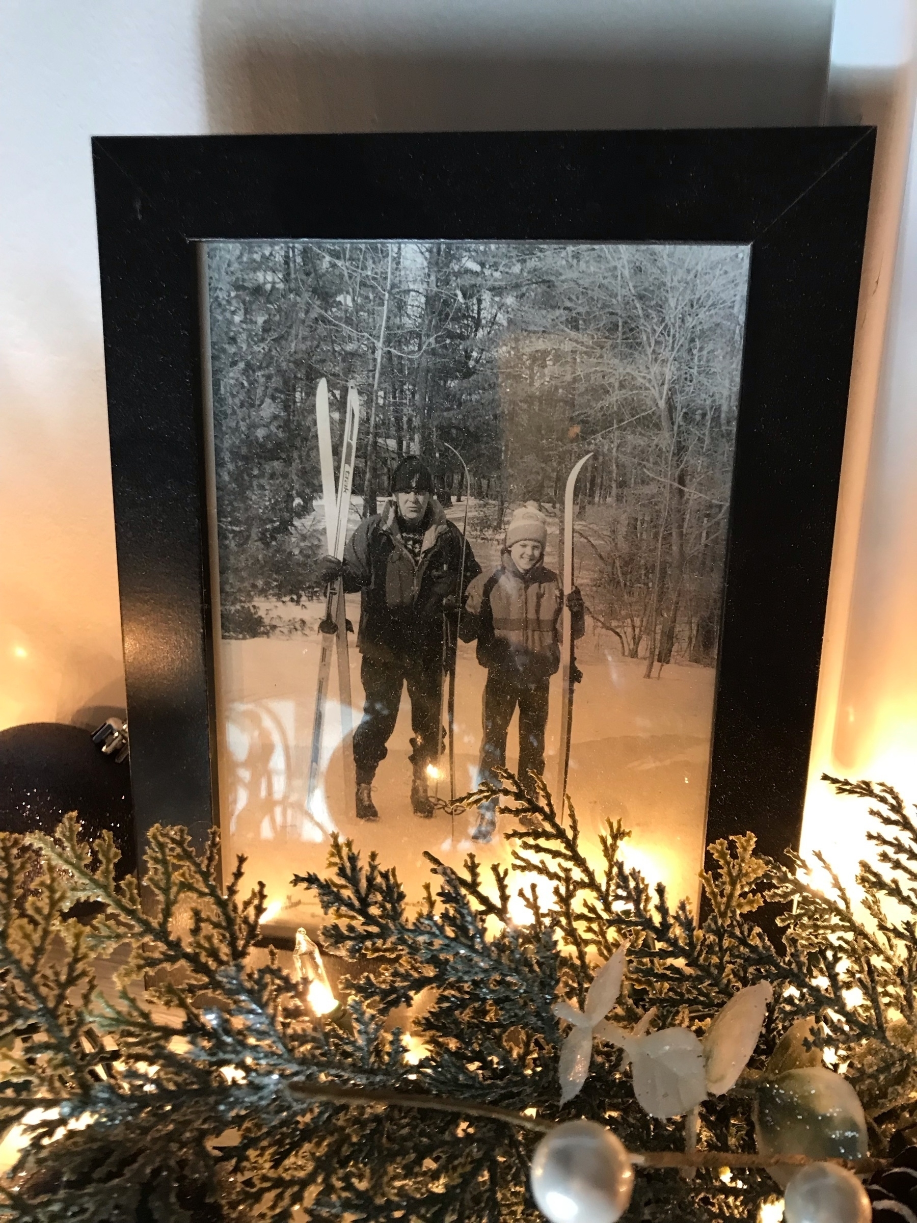 Picture of a framed photo of my dad and I skiing when I was young, taken last Christmas and silhouetted by lights