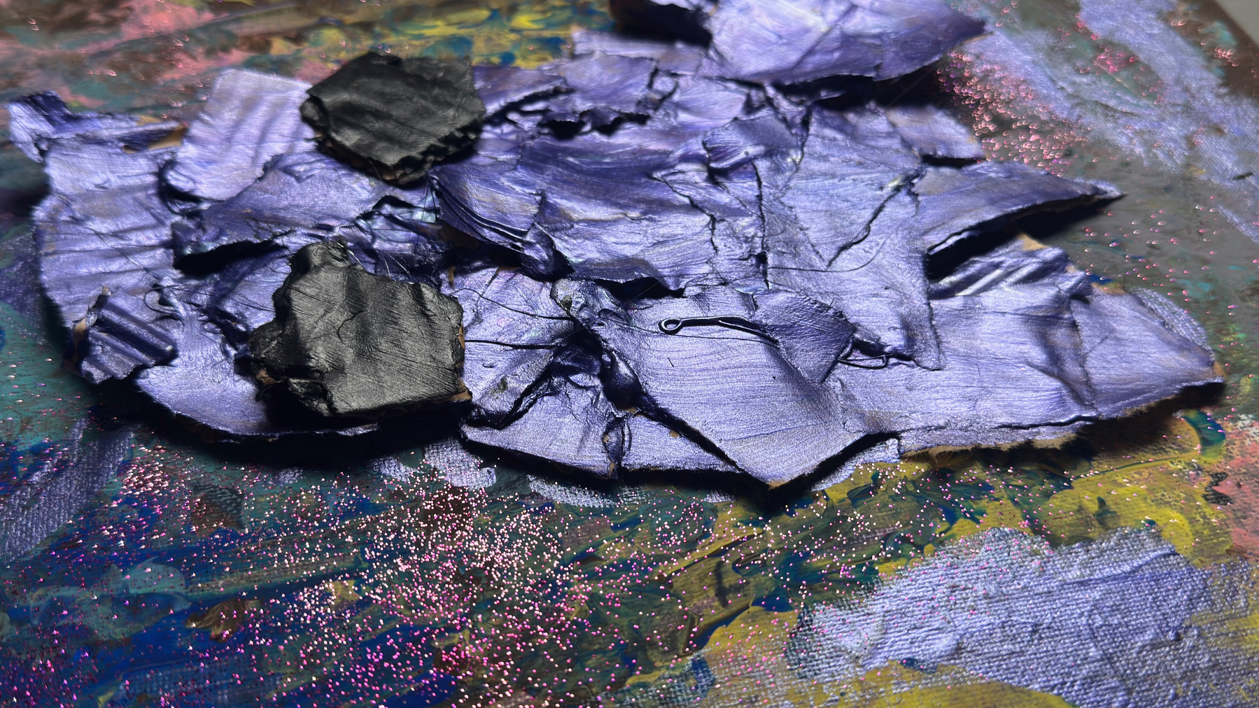 Auto-generated description: Layers of textured purple and black paint with glitter create an abstract, vibrant composition.