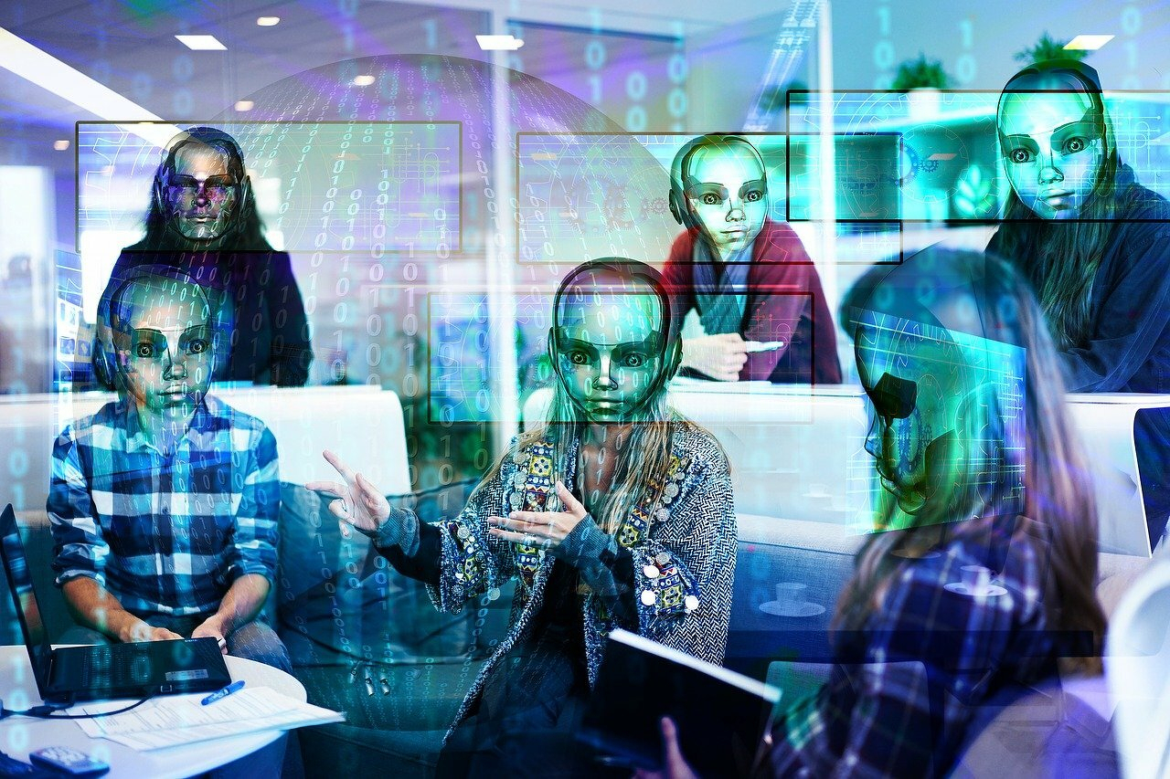 A group of individuals are engaged in a meeting, with digital overlays of alien-like faces and binary code covering the scene. From geralt.