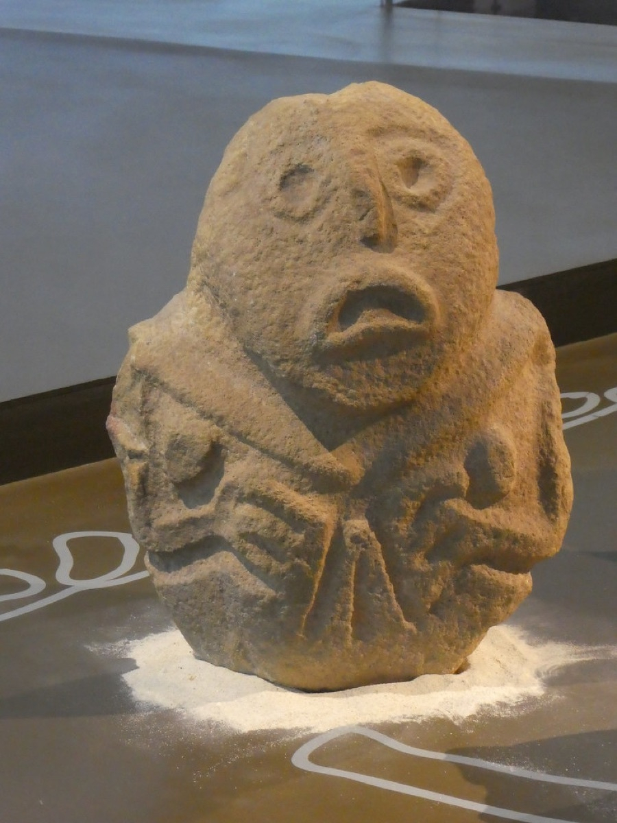 Sandstone sculpture of a human-fish hybrid from Lepenski Vir, displayed in a museum case
