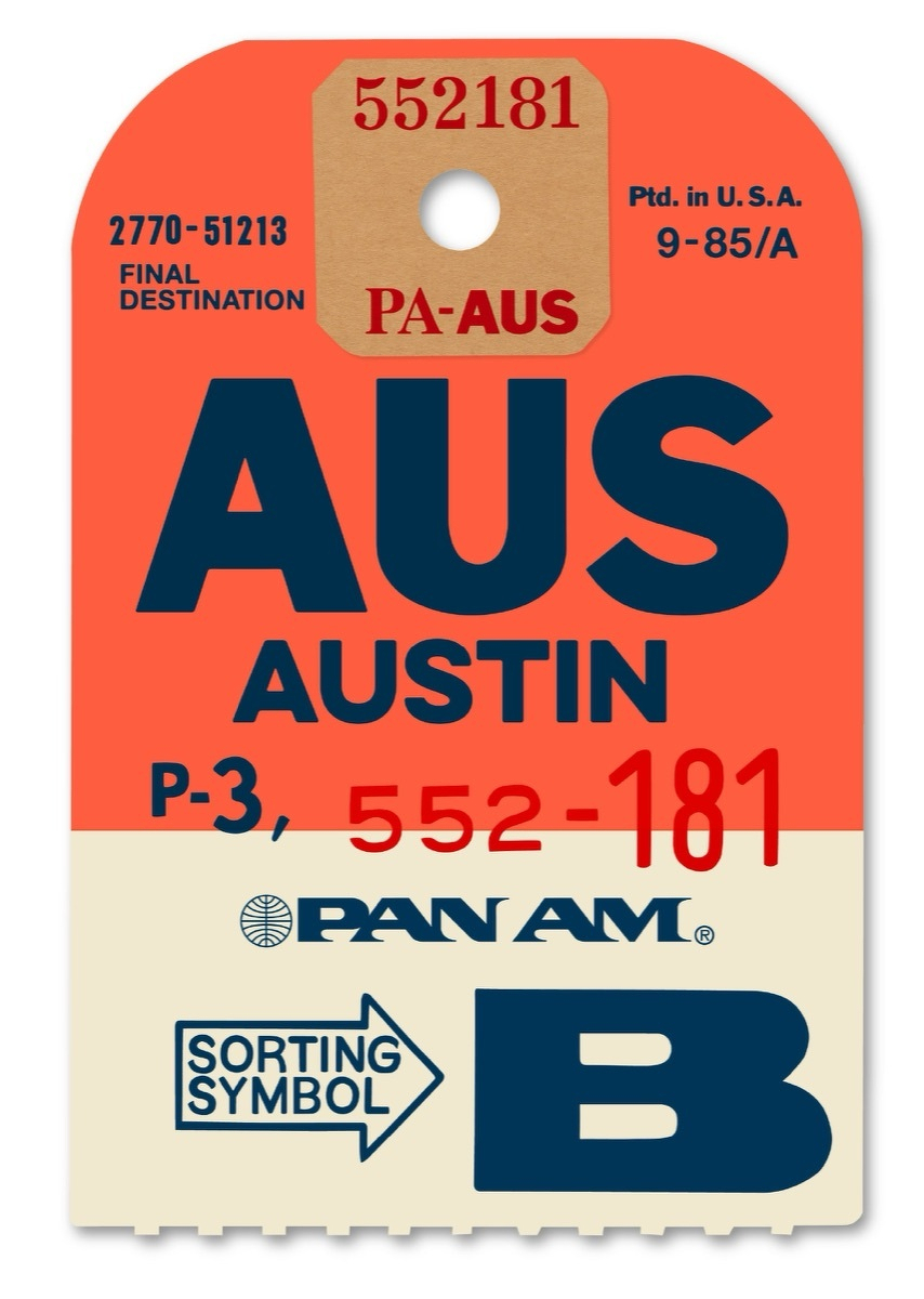 Vintage Pan Am airline luggage tag in orange and cream, marked AUS / AUSTIN in bold navy lettering, with route code PA-AUS, reference numbers 2770-51213 and 552-181, the Pan Am globe logo, and a SORTING SYMBOL B arrow at the bottom.